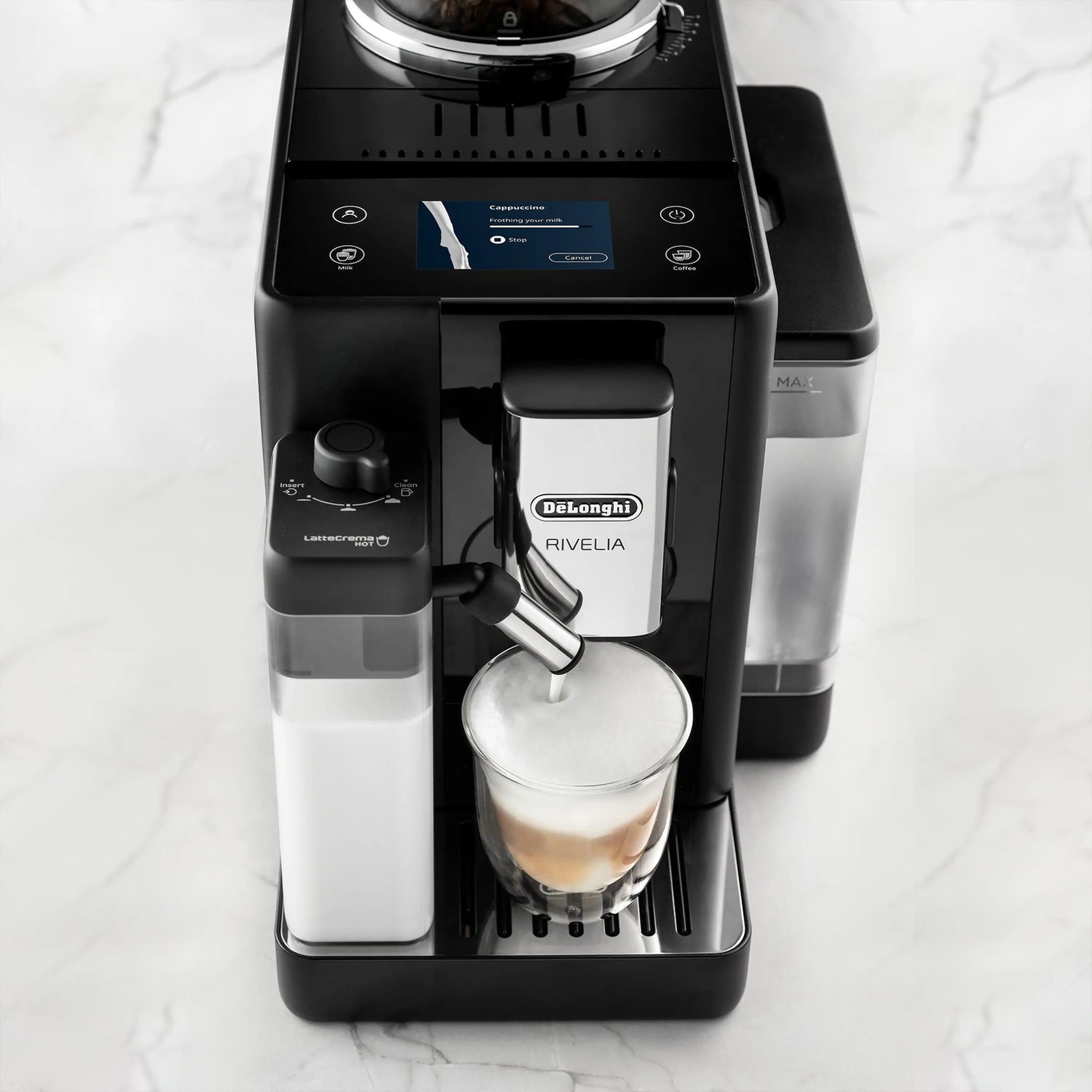 Front view of black espresso machine with dispensing spout and glass of espresso.
