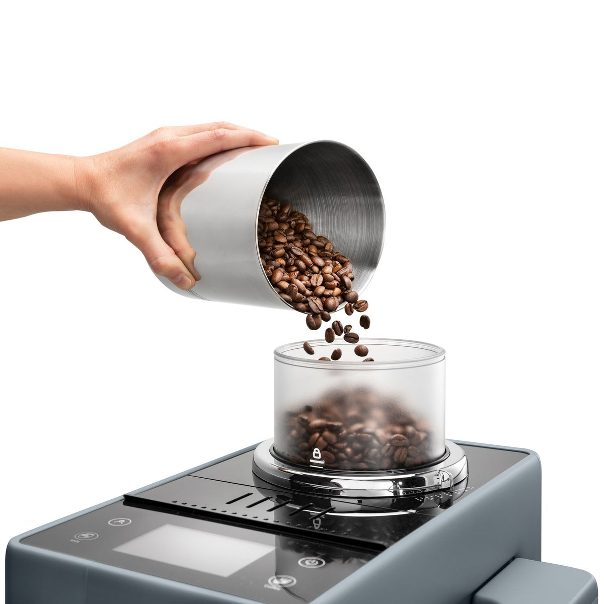 Coffee beans poured from metal canister into hopper on pebble gray espresso machine