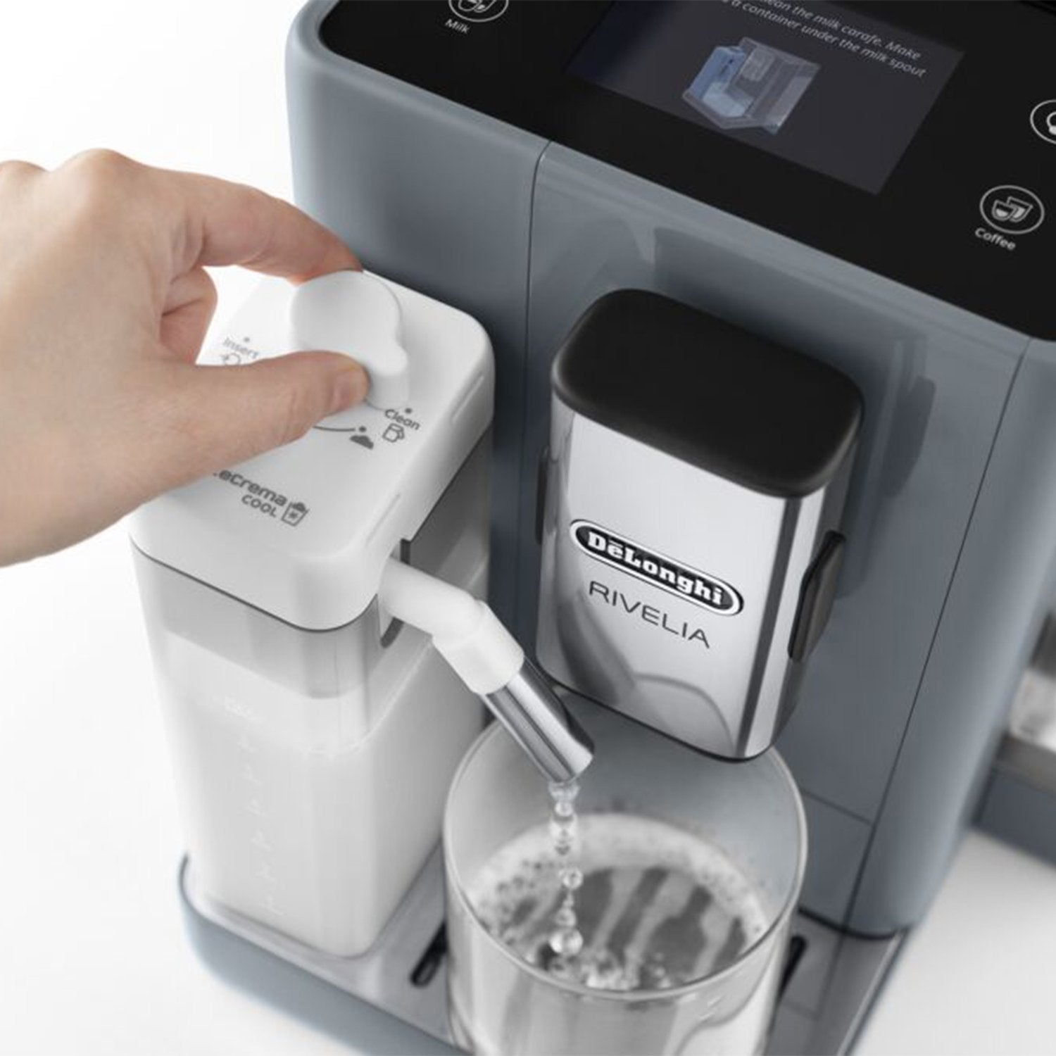 Hand attaching a milk container to the nozzle of a pebble gray espresso machine