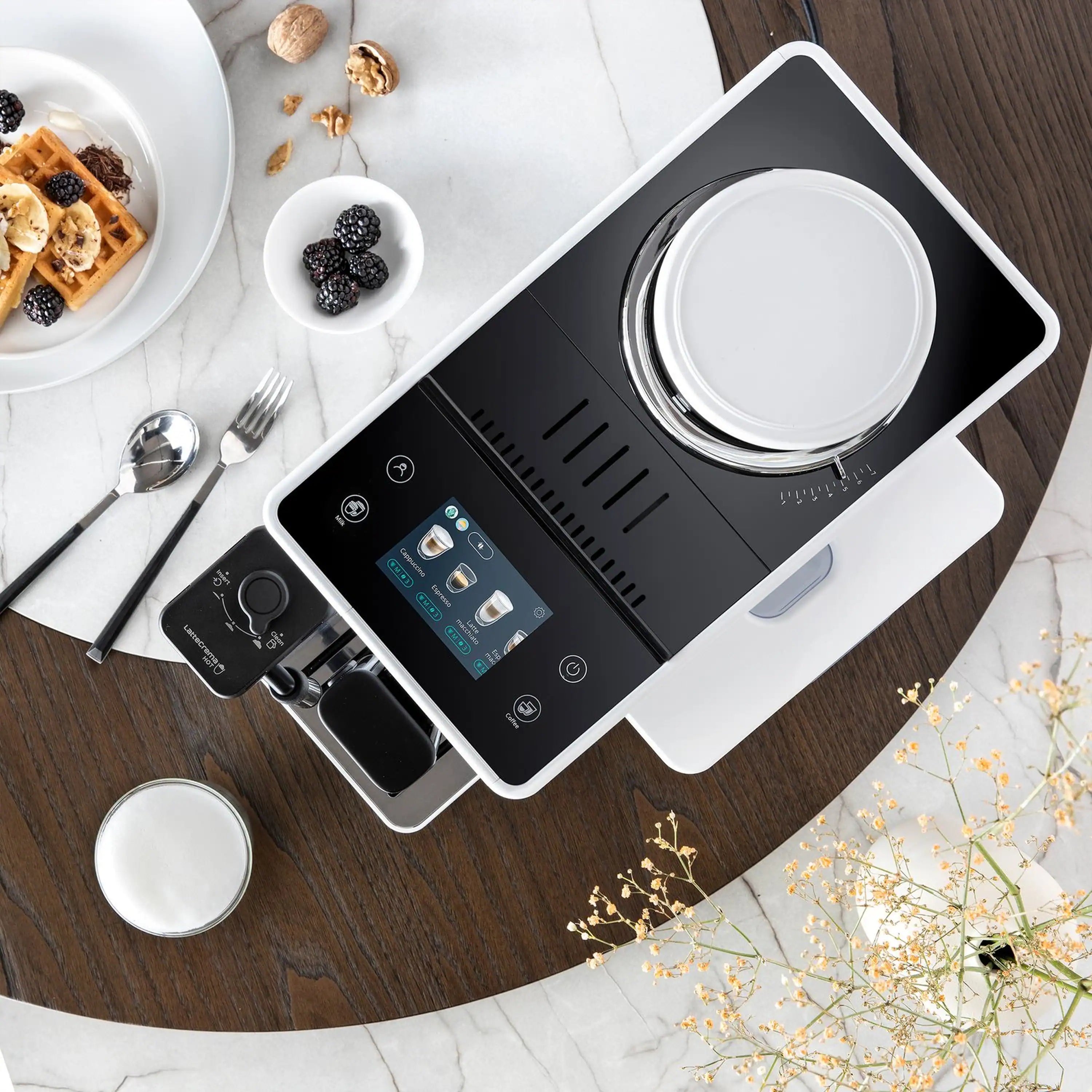 White espresso machine on tabletop with touchscreen control panel and accessories