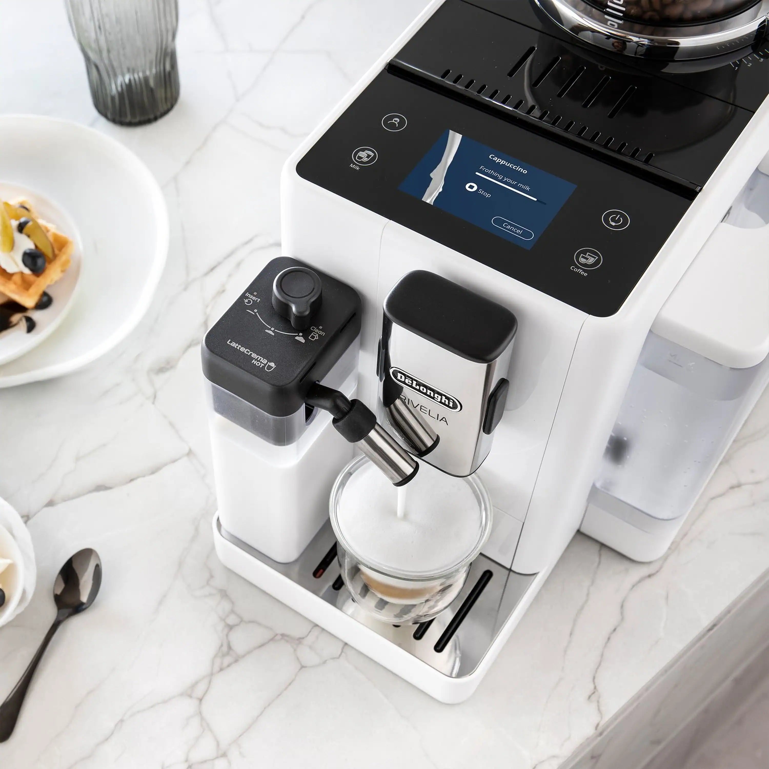 White espresso machine close-up with control screen, spout, and frothing unit