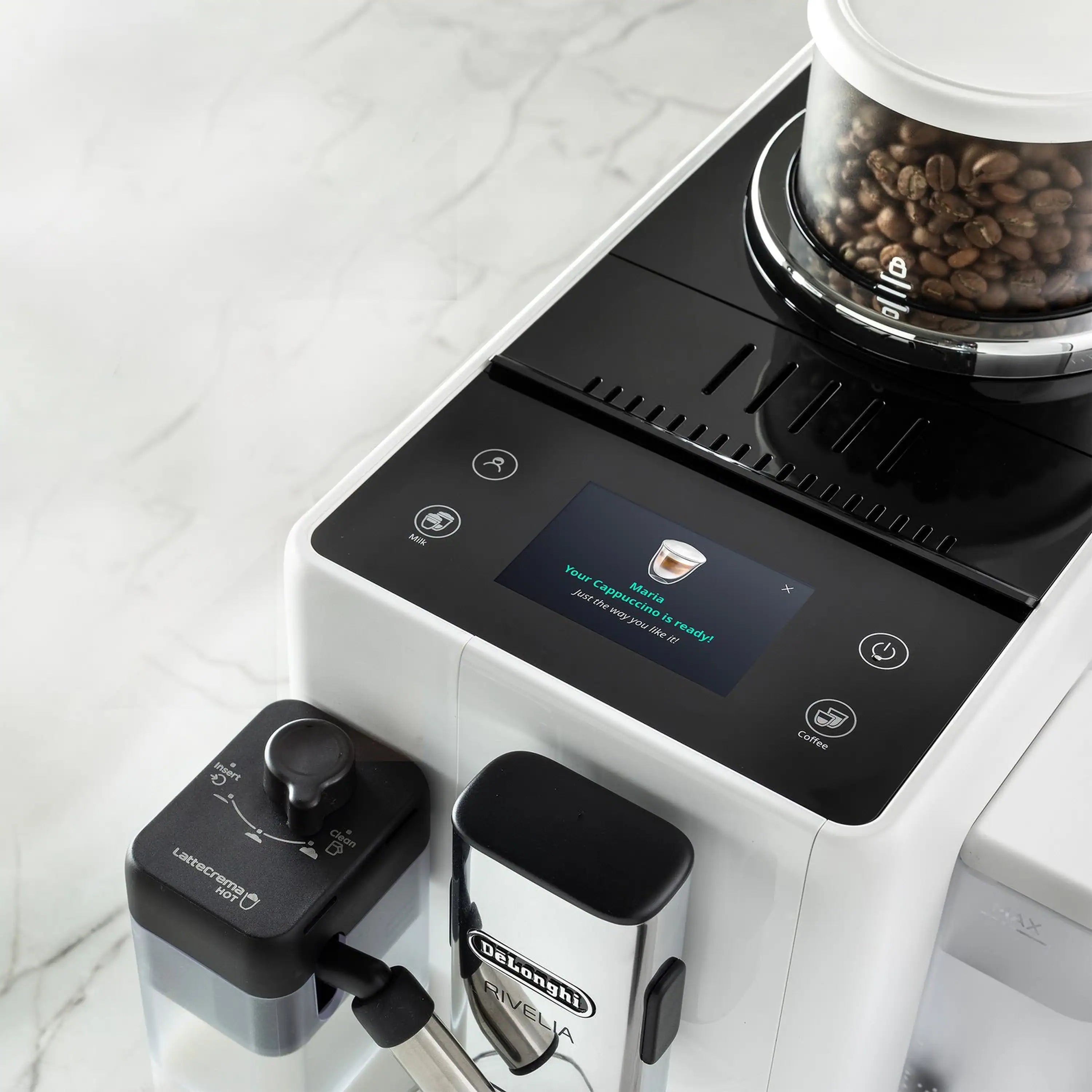 White espresso machine close-up showing black top panel and bean hopper