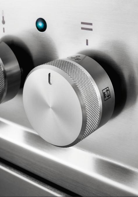 Stainless steel gas range control knob close-up with indicator markings
