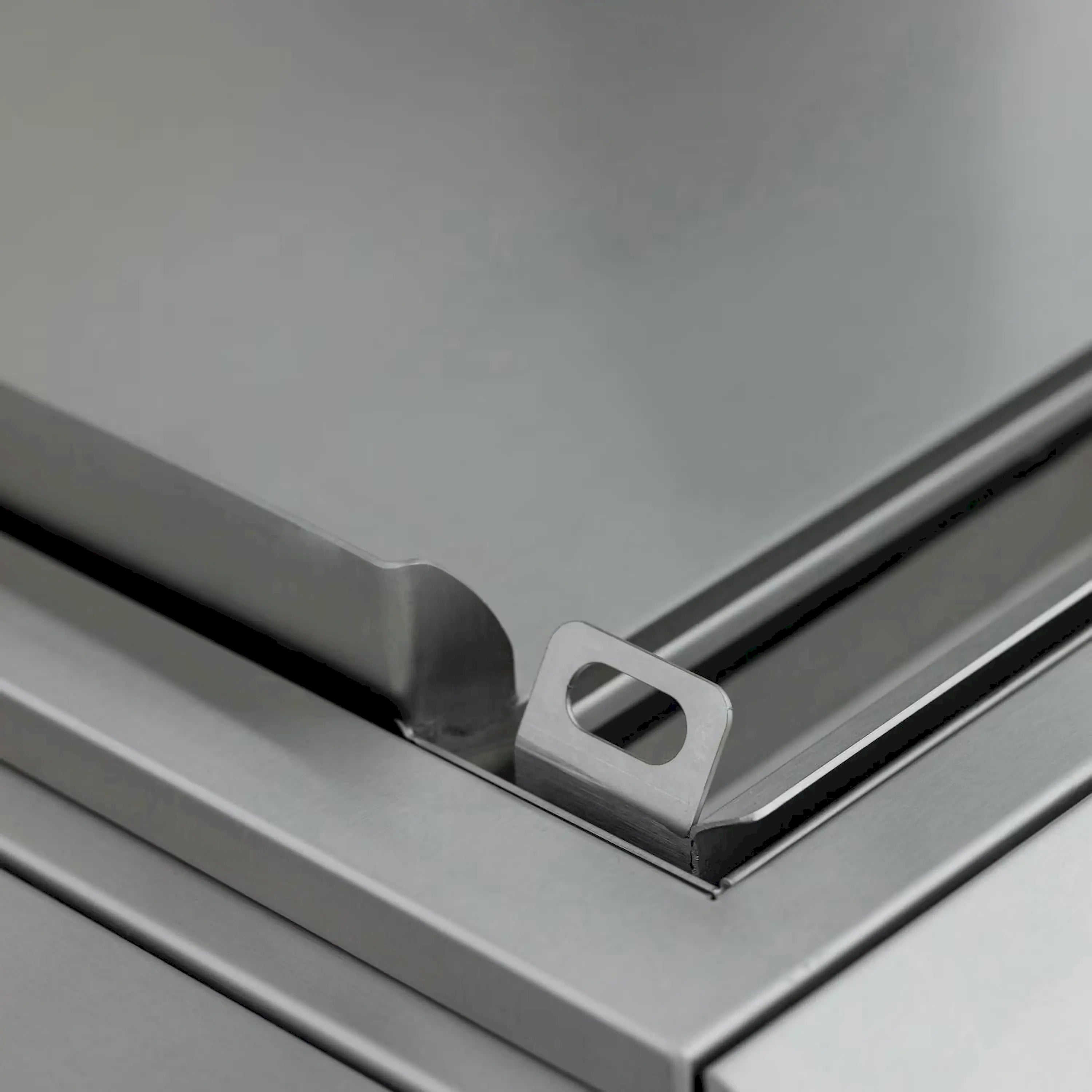 Stainless steel griddle front rail with mounting bracket and opening