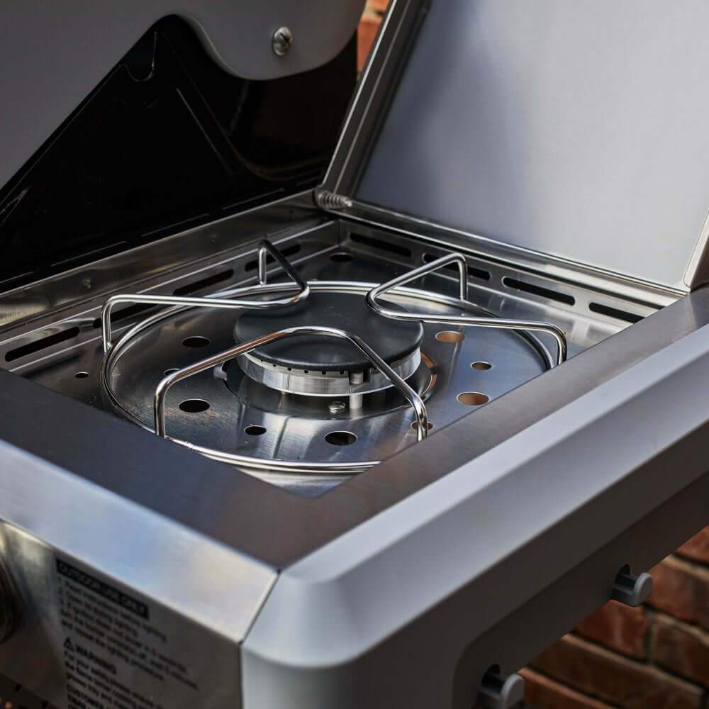 Open stainless steel grill firebox with burners and cooking grates