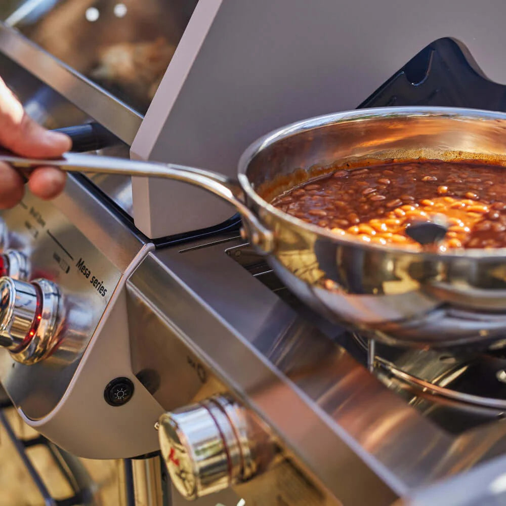 Stainless steel grill with a cooking pot on the burners