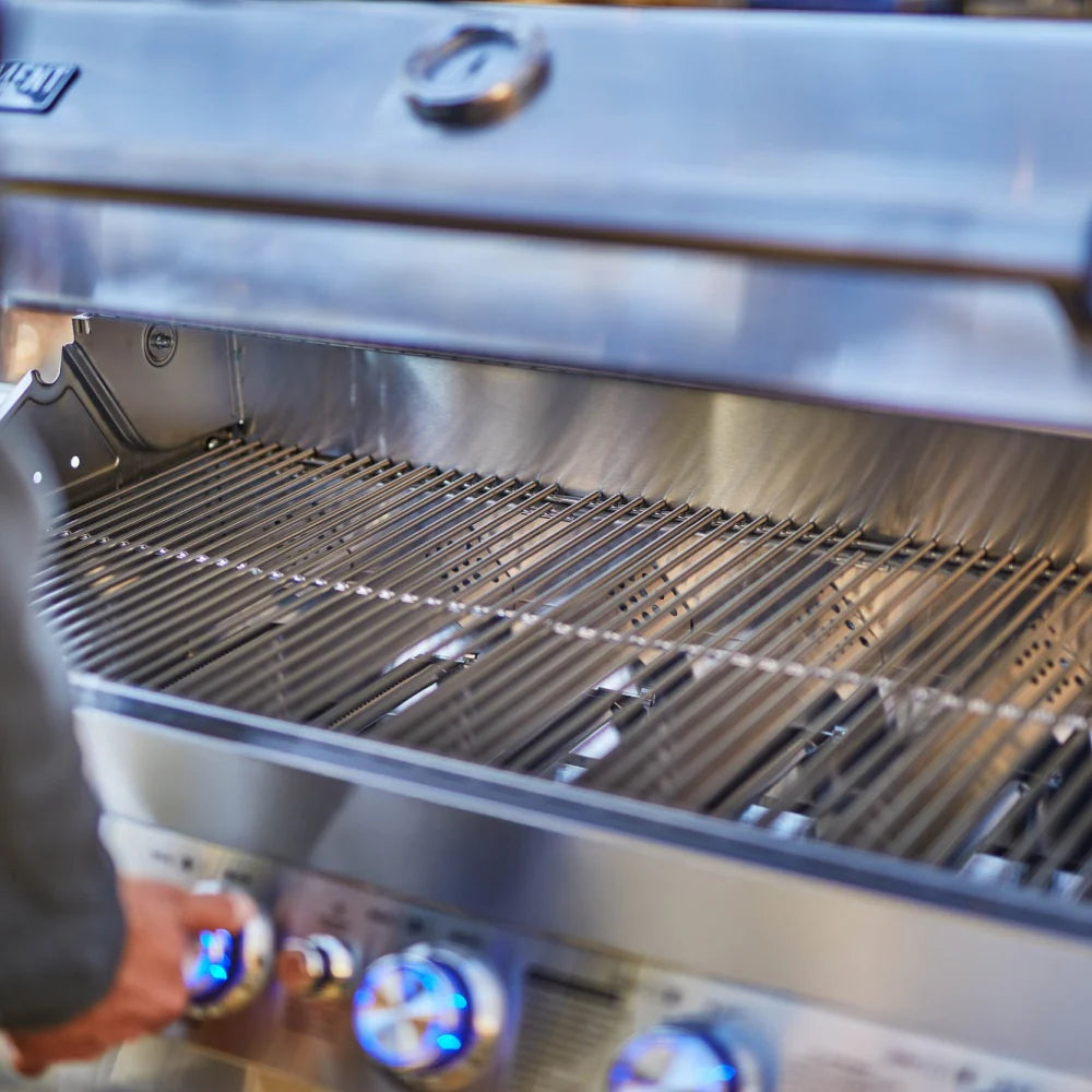 Stainless steel propane gas grill interior with cast-iron cooking grates