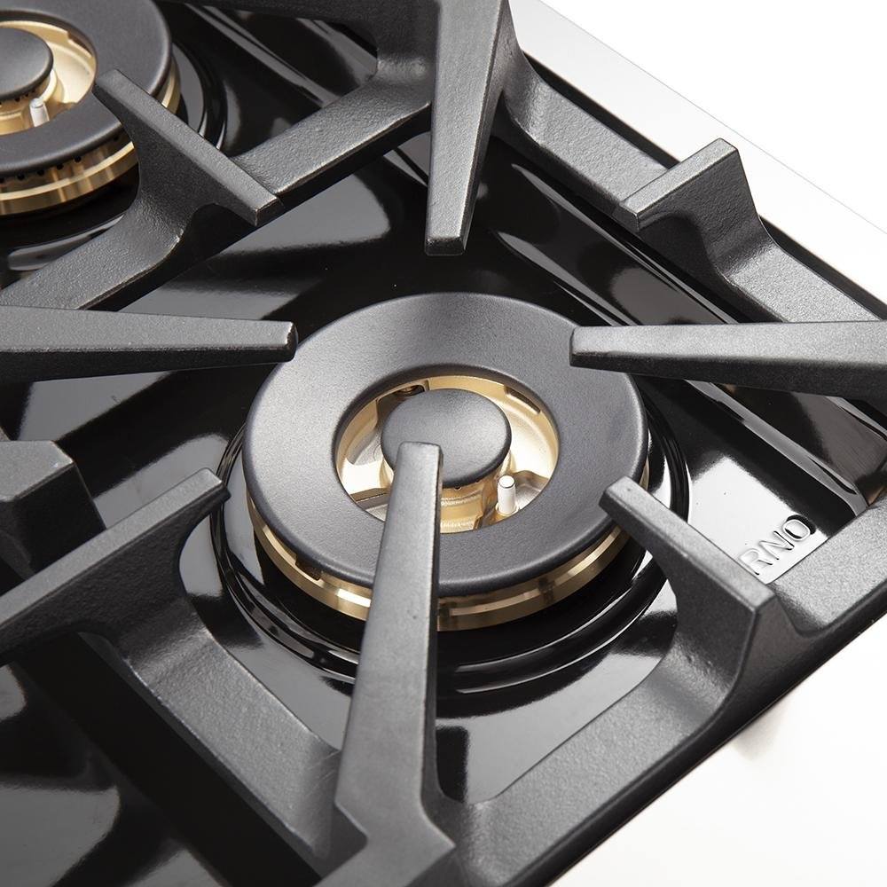 Stainless steel gas cooktop burner with black cast-iron grate and brass accents