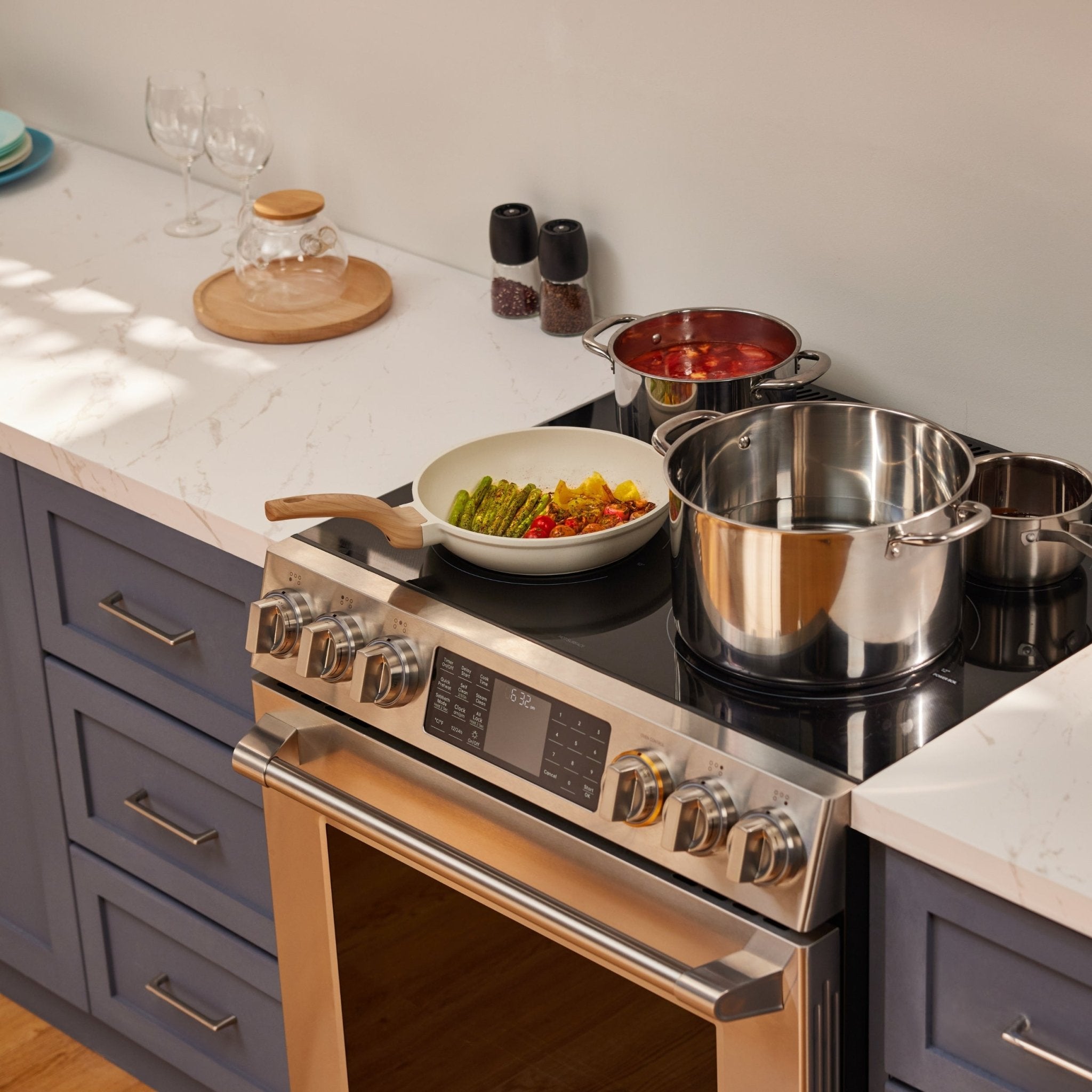 Stainless slide-in electric range cooktop with pot and skillet on burners