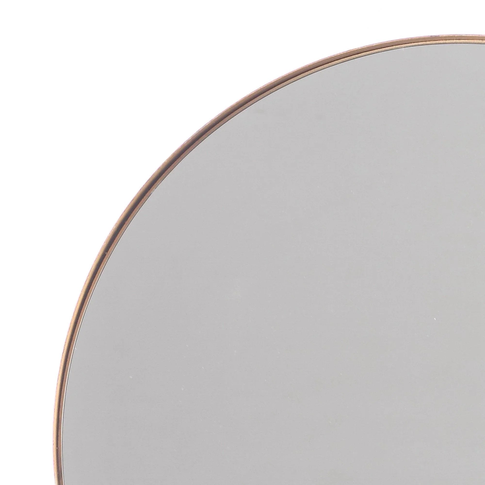 Close-up of round mirror edge with thin golden rim and gray glass.