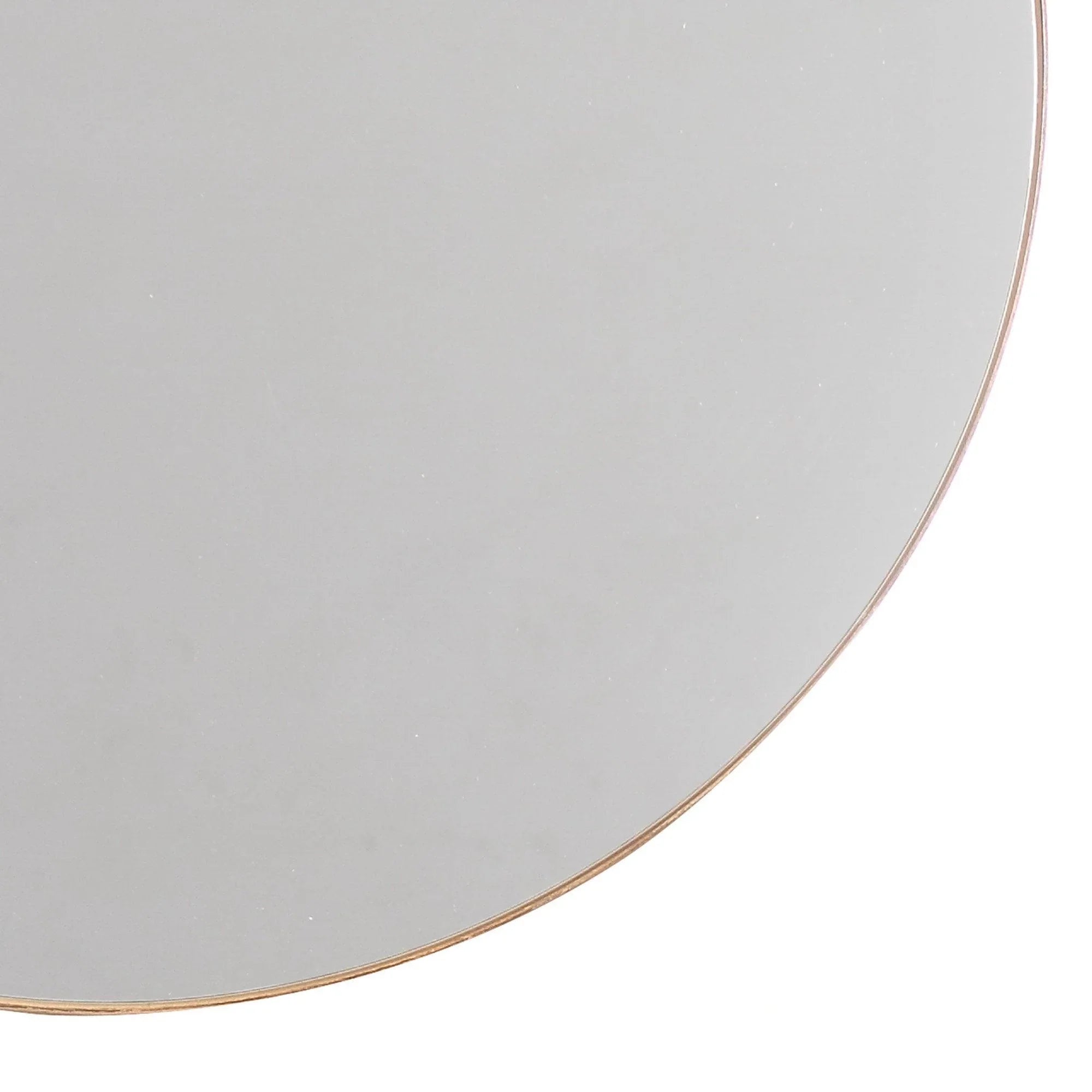 Close-up detail of round mirror showing thin golden metal border.