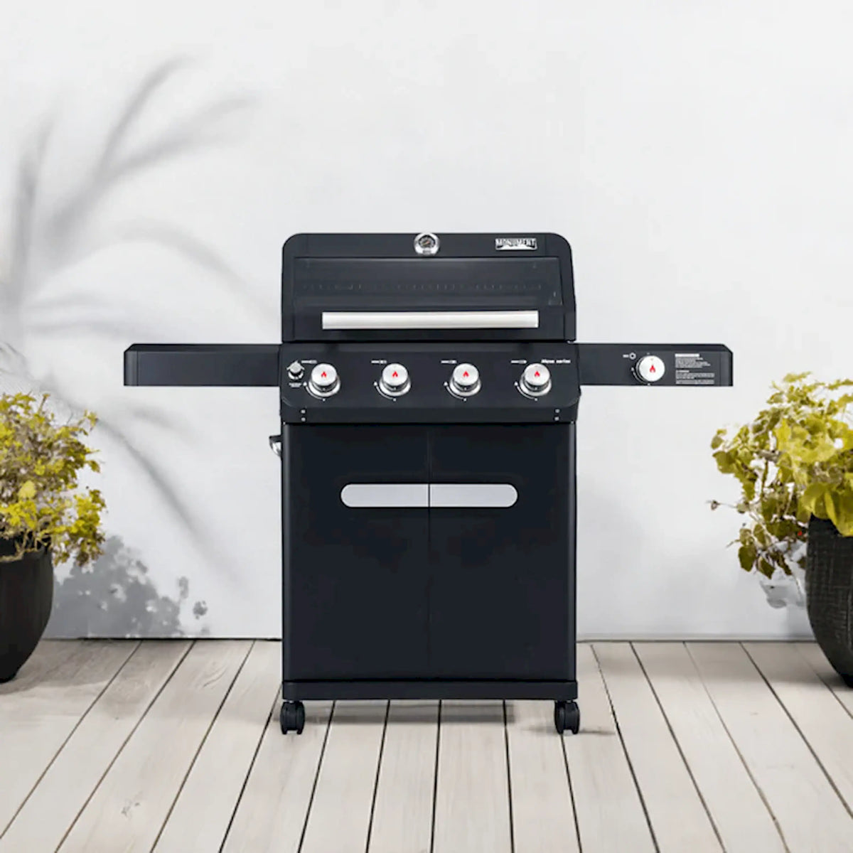 Black propane gas grill with four burners, side shelf, and cart base on wheels