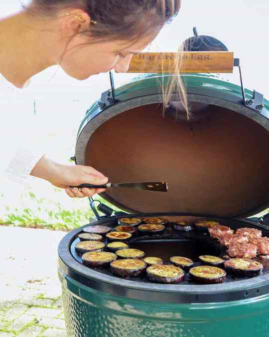 Flat top griddle insert in use with browned vegetables and meat on flat surface