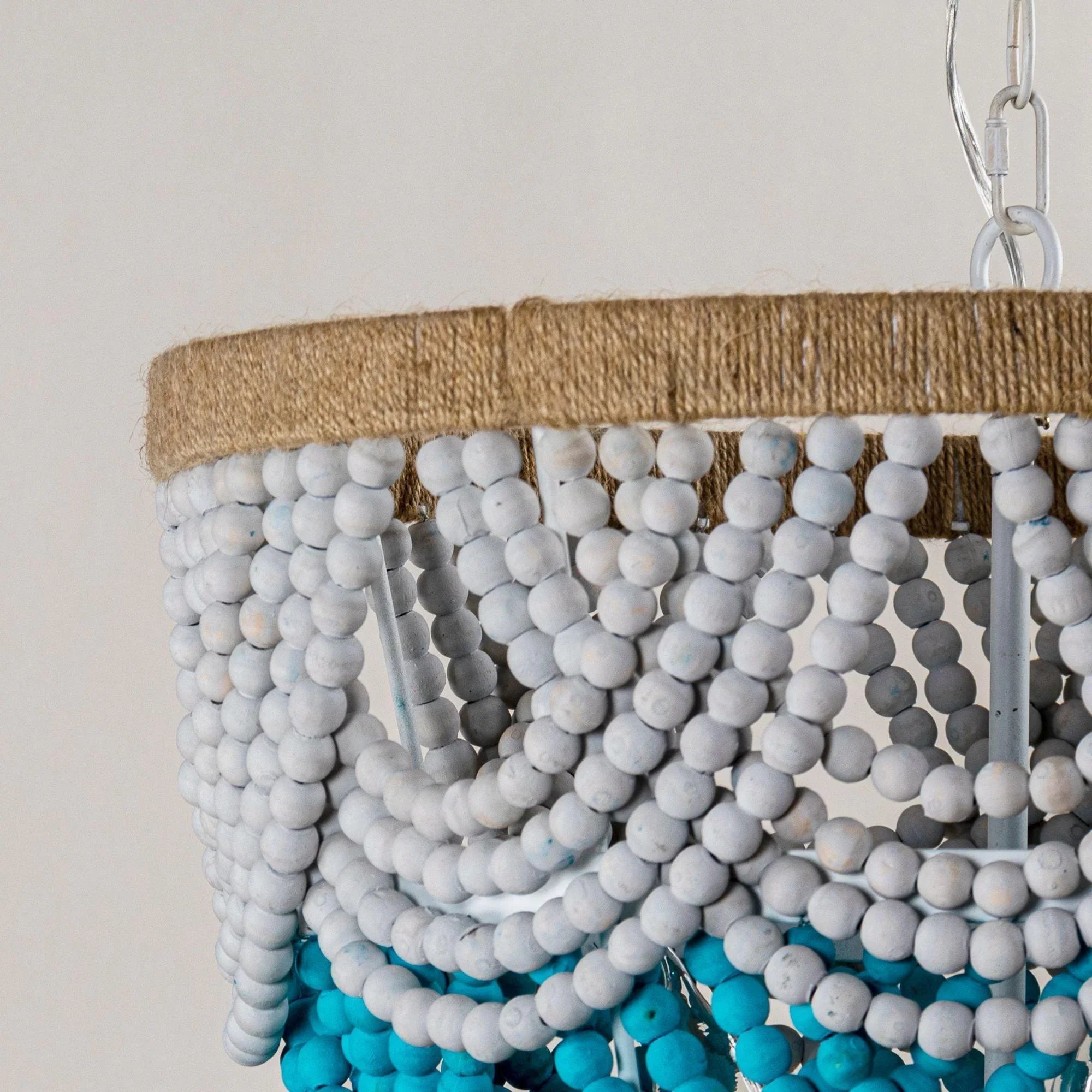 Close-up of white bead shade with turquoise bead band and hanging beaded strands