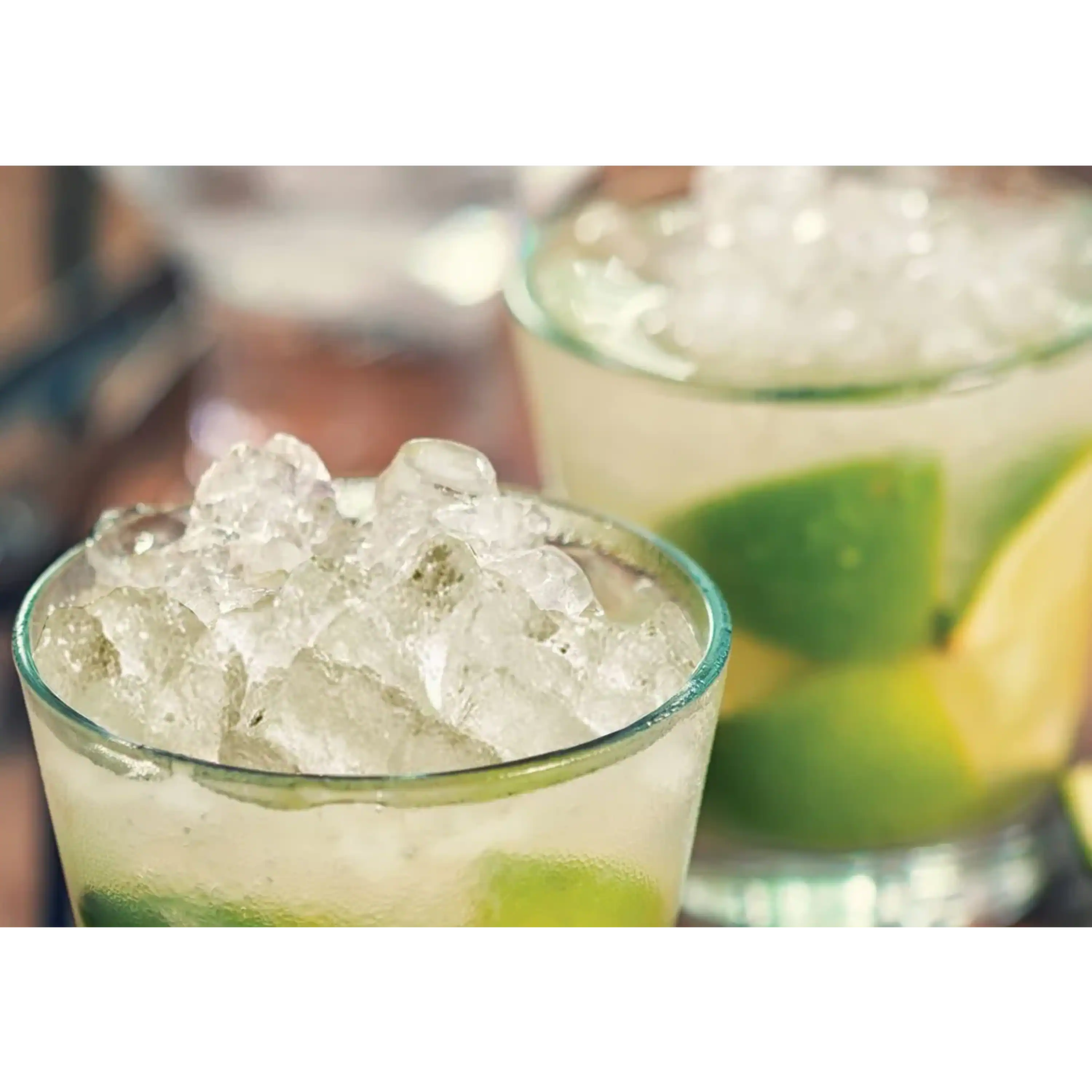 Glass of cubelet ice with lime and yellow citrus garnish