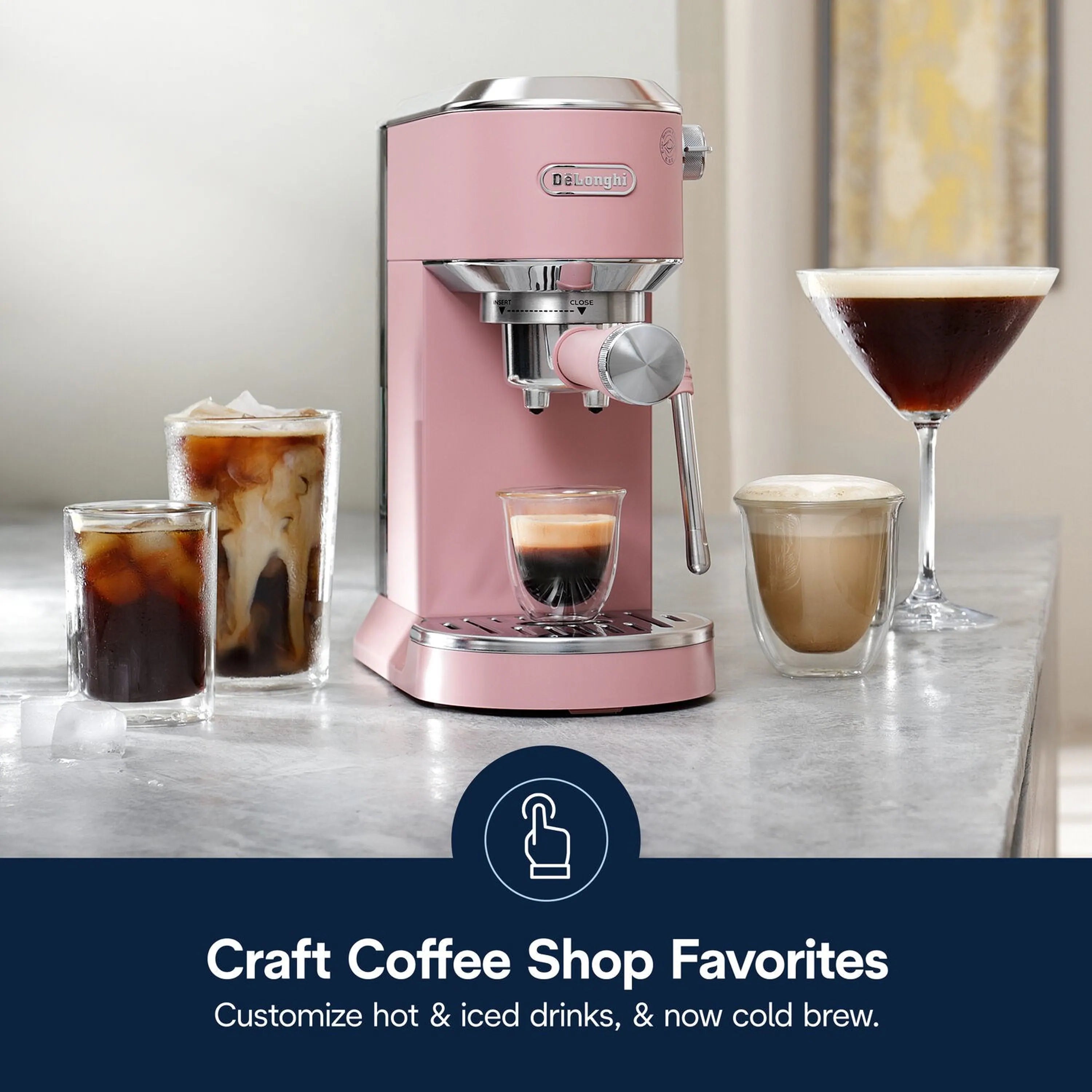 Pink De'Longhi espresso machine with frothing wand, three coffee drinks on countertop