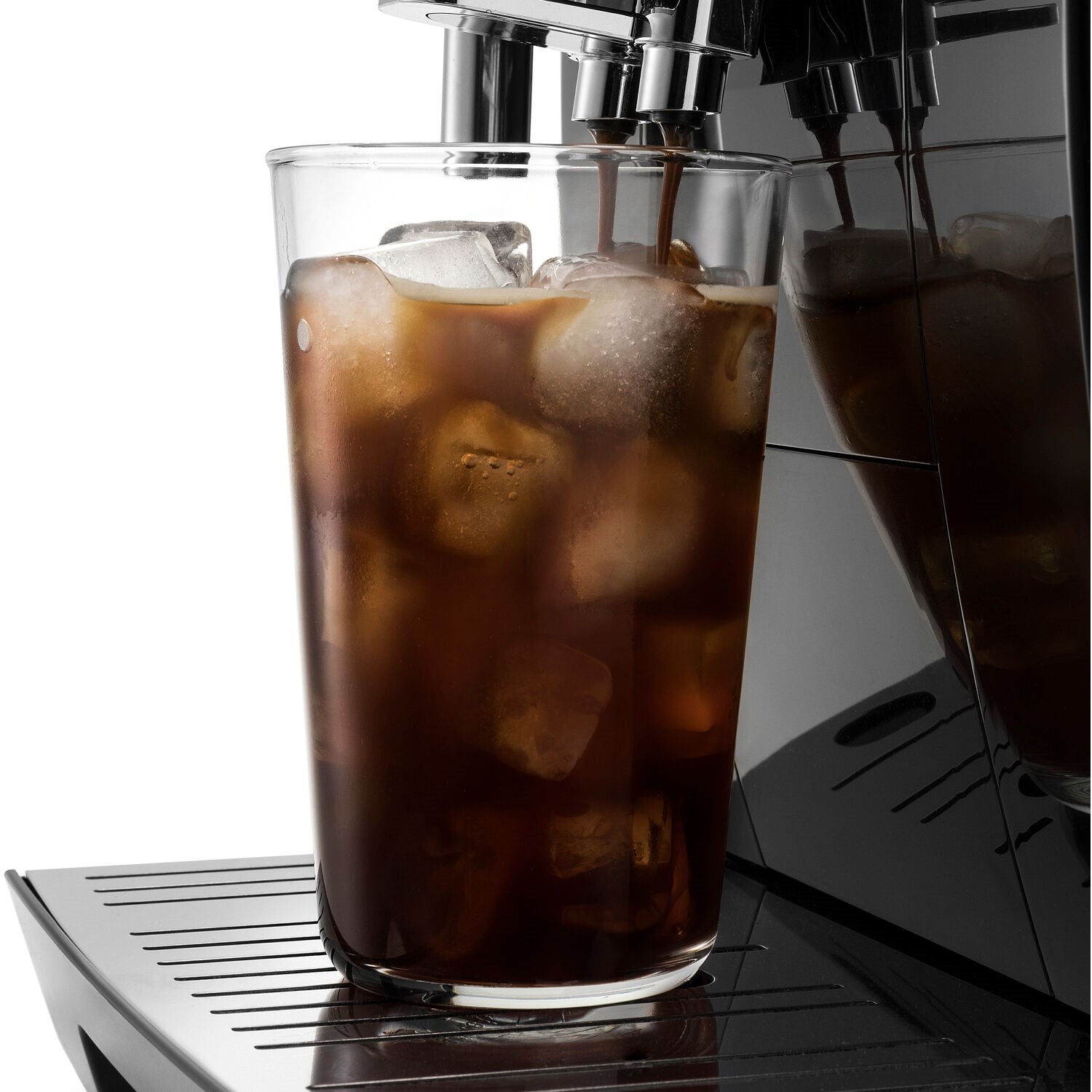 Double-wall glass with iced coffee and ice cubes, on espresso machine drip area