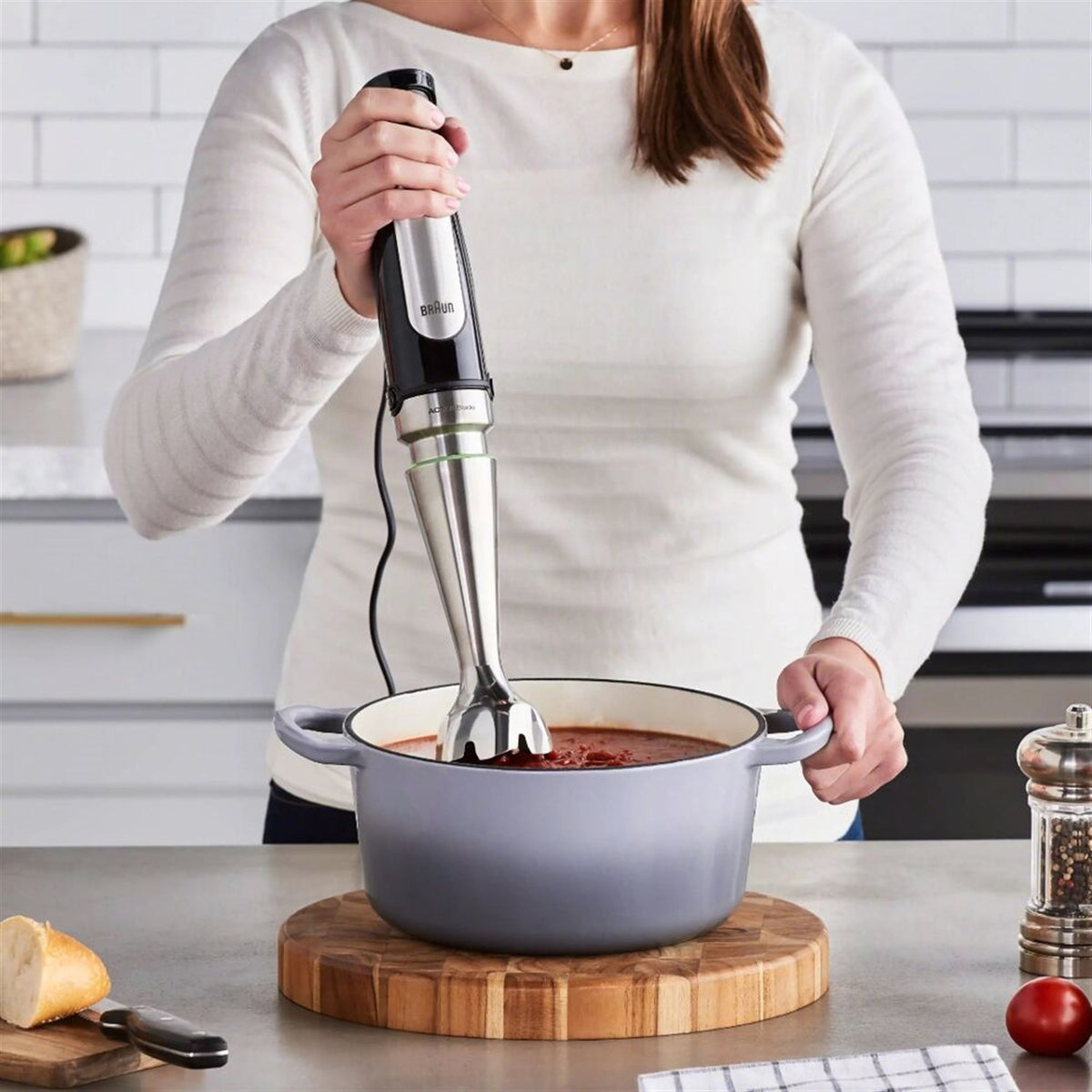 Stainless steel and black Braun hand blender with immersion shaft, blending in pot