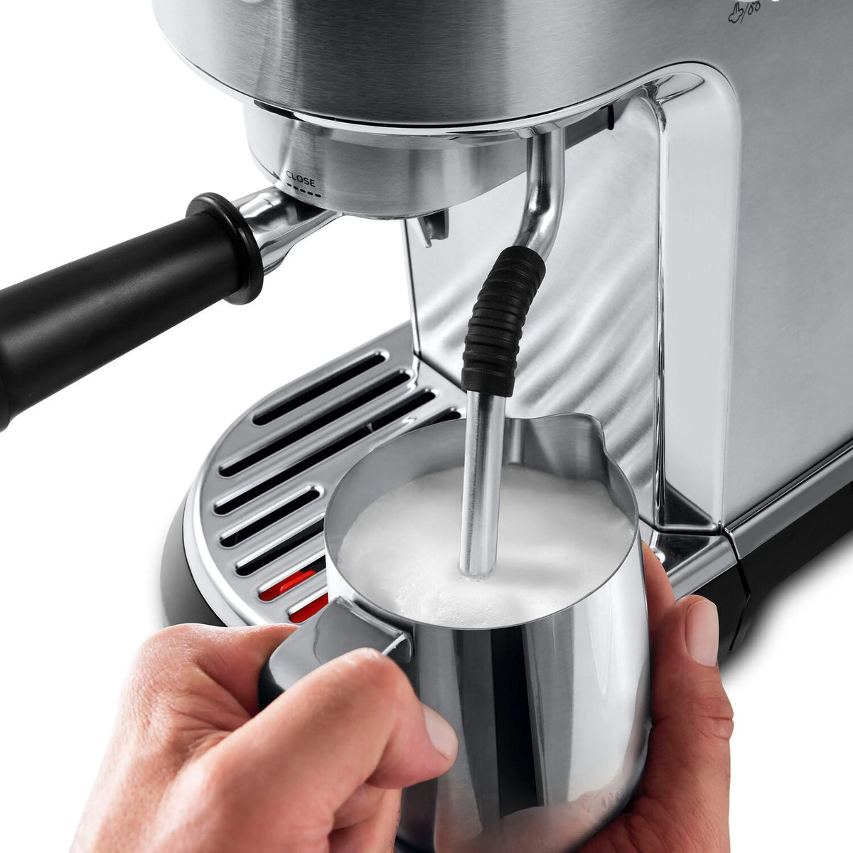 Stainless steel espresso machine with automatic steam wand pouring into a metal cup