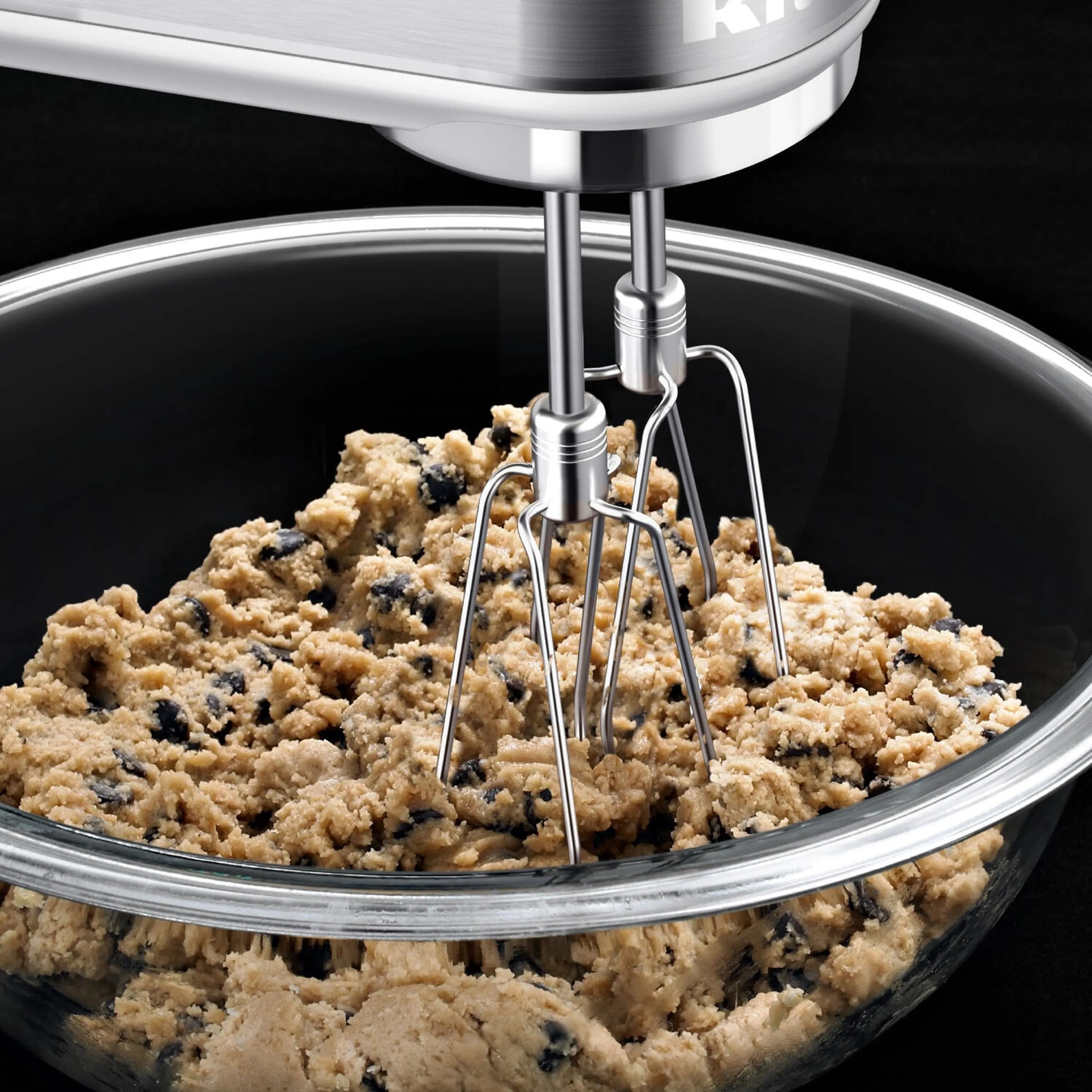 White hand mixer beater attachment mixing batter in a bowl