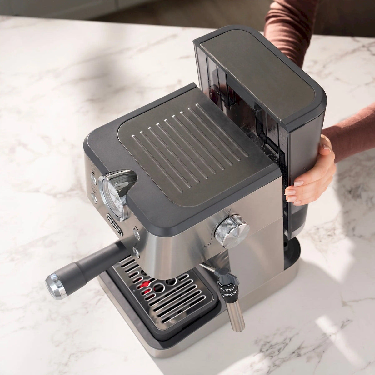 Espresso machine with open top lid and black drip tray, shown at an angle.