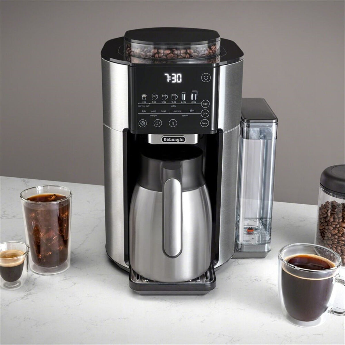 De'Longhi TrueBrew coffee maker with display lit, thermal carafe, and two coffee cups