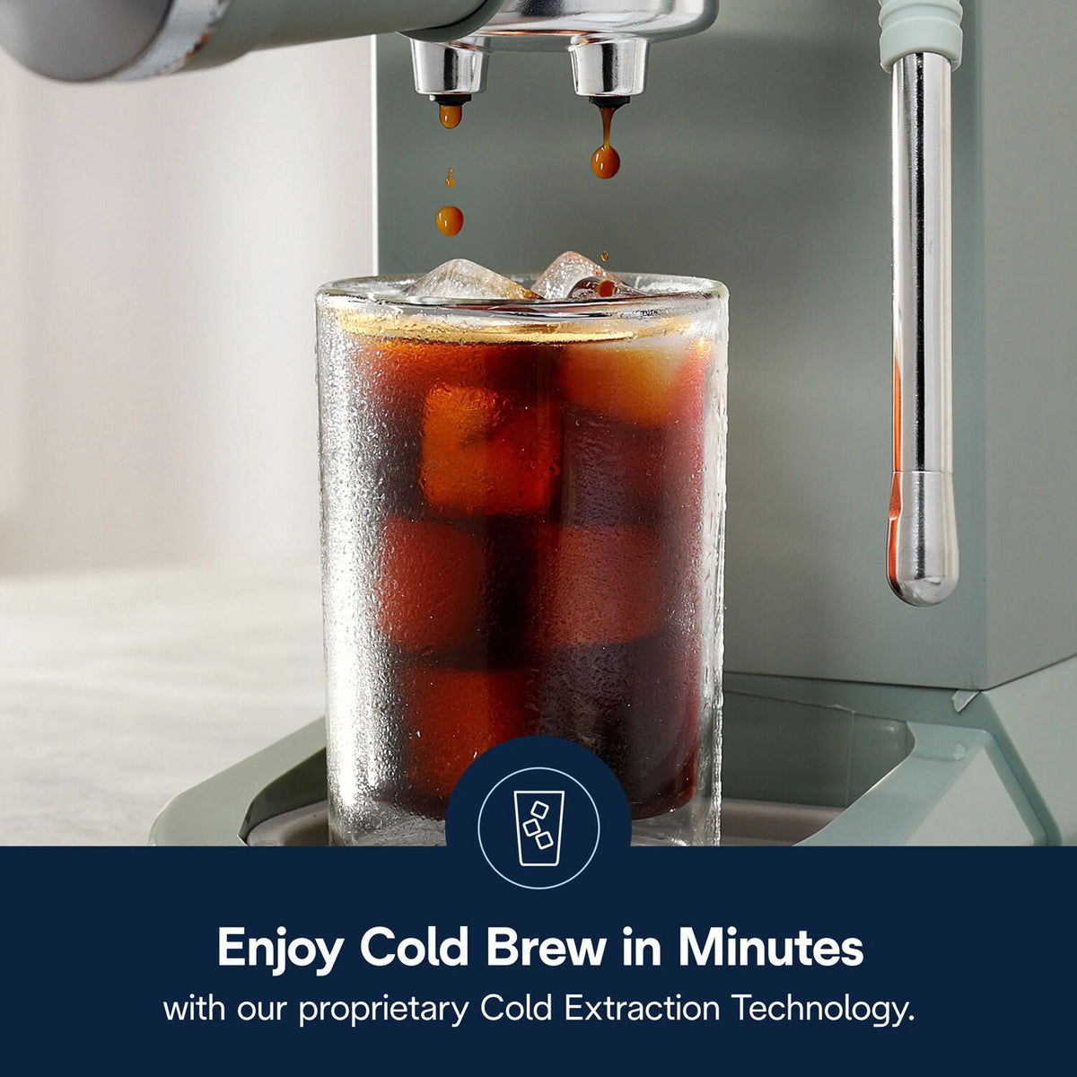Green De'Longhi machine dispensing cold brew into tall glass cup with ice