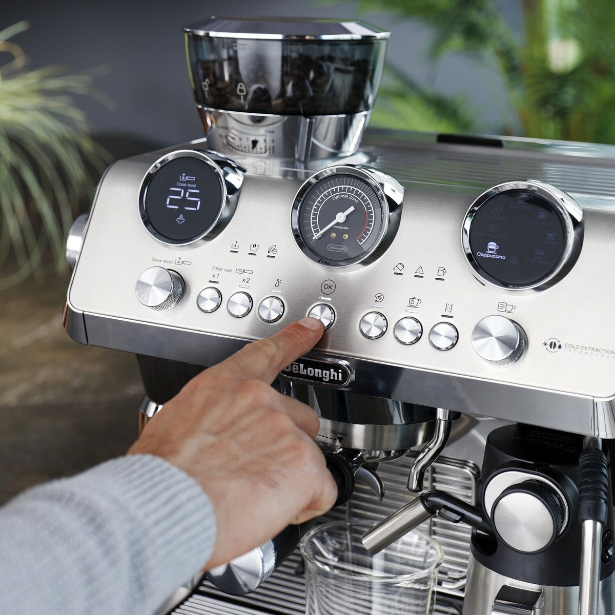 Stainless steel espresso machine with LCD and round control dials, front panel close-up