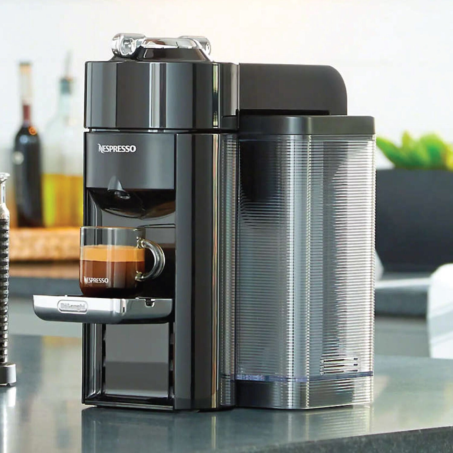 Single-serve coffee and espresso machine with frothy cup on the drip tray