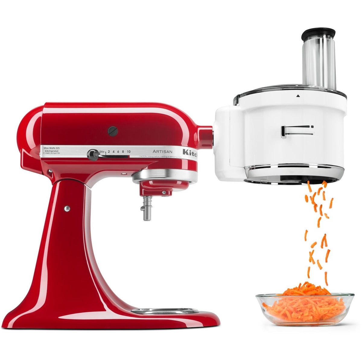 Red stand mixer with food processor attachment shredding carrots into a glass bowl