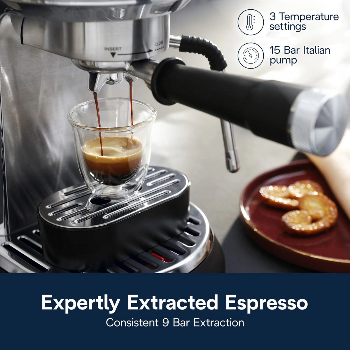 Stainless steel espresso machine brewing espresso into a glass cup under the spout