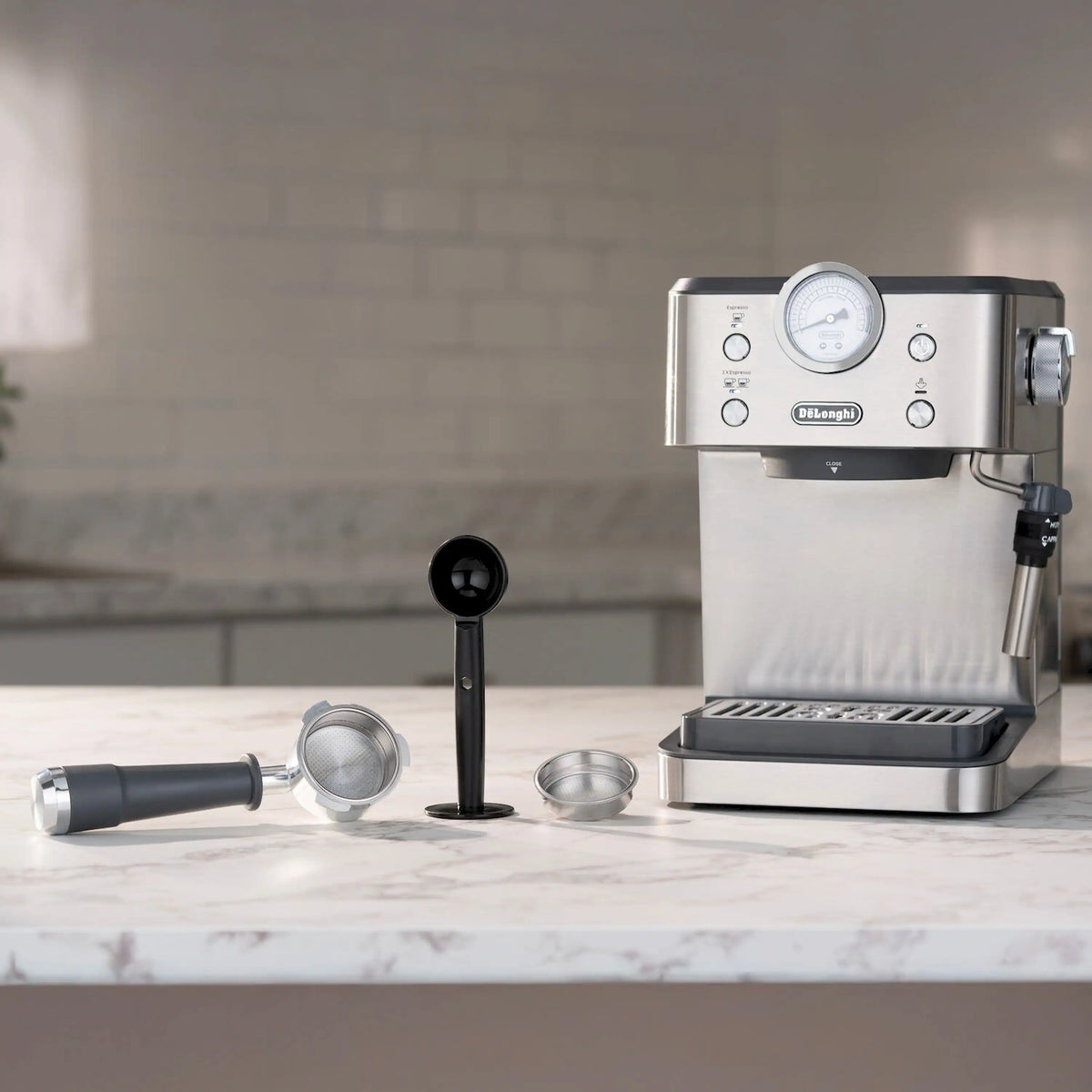 Stainless espresso machine with milk frother on countertop, portafilter and accessories nearby