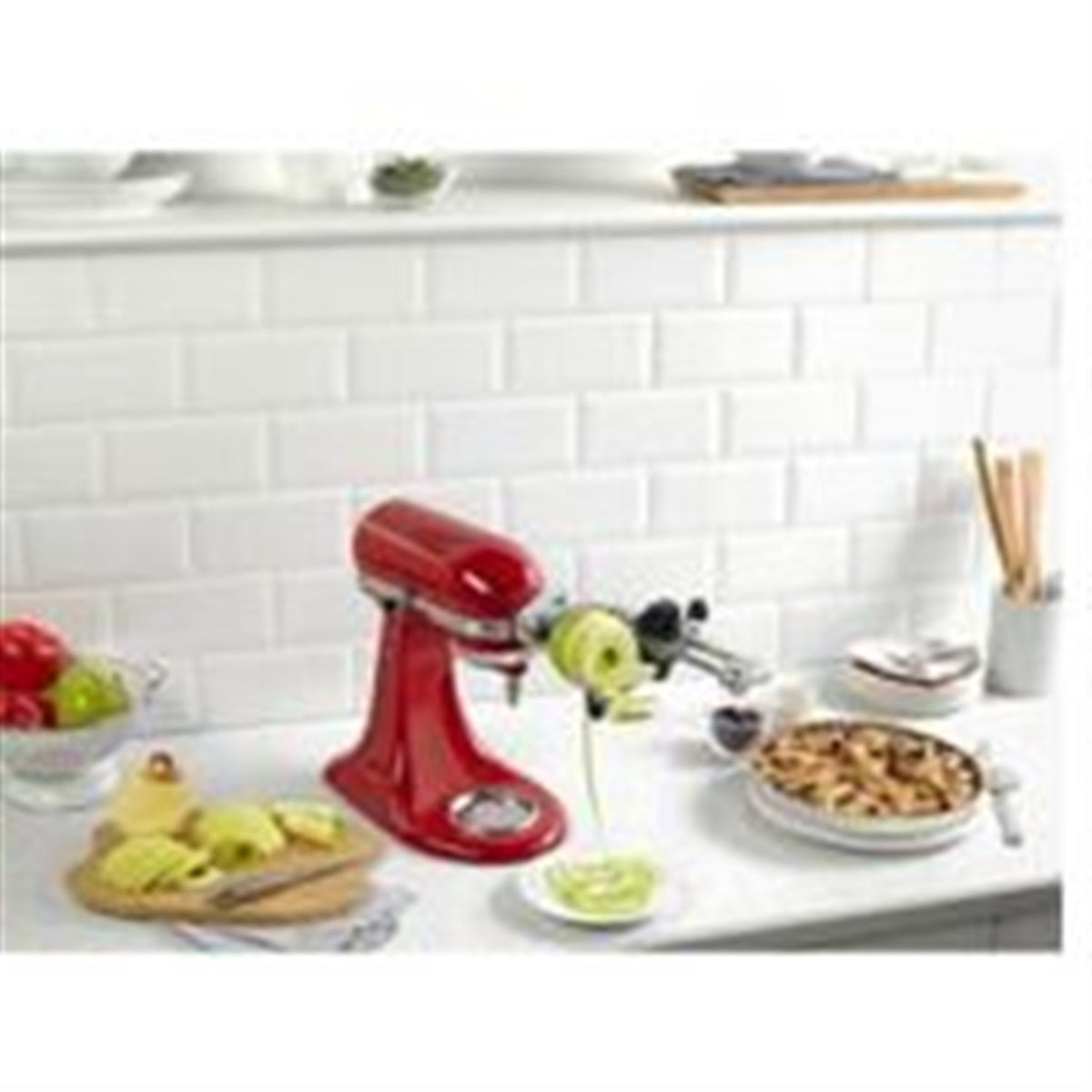 Spiralizer attachment on red stand mixer with sliced and spiralized vegetables