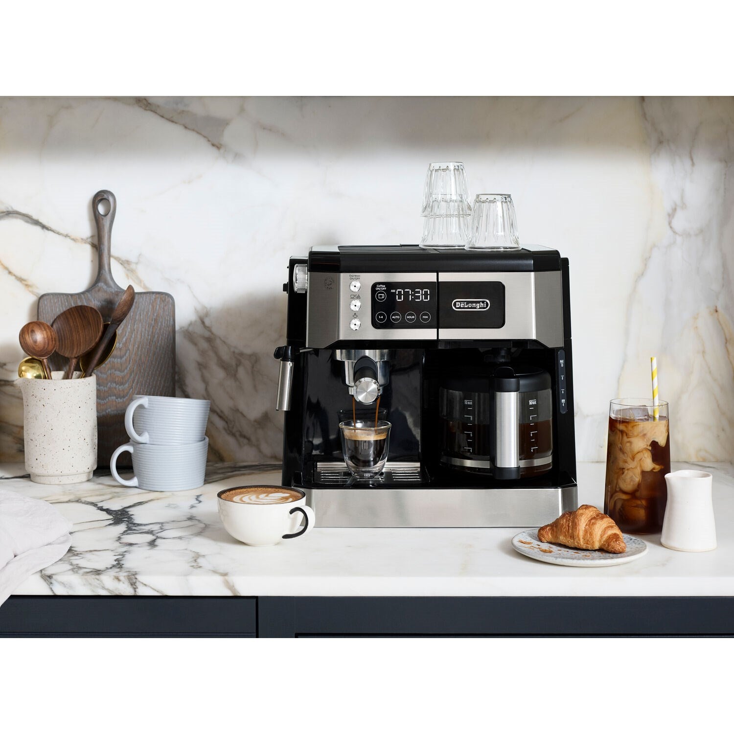 Stainless and black De'Longhi espresso and drip machine on countertop with cups