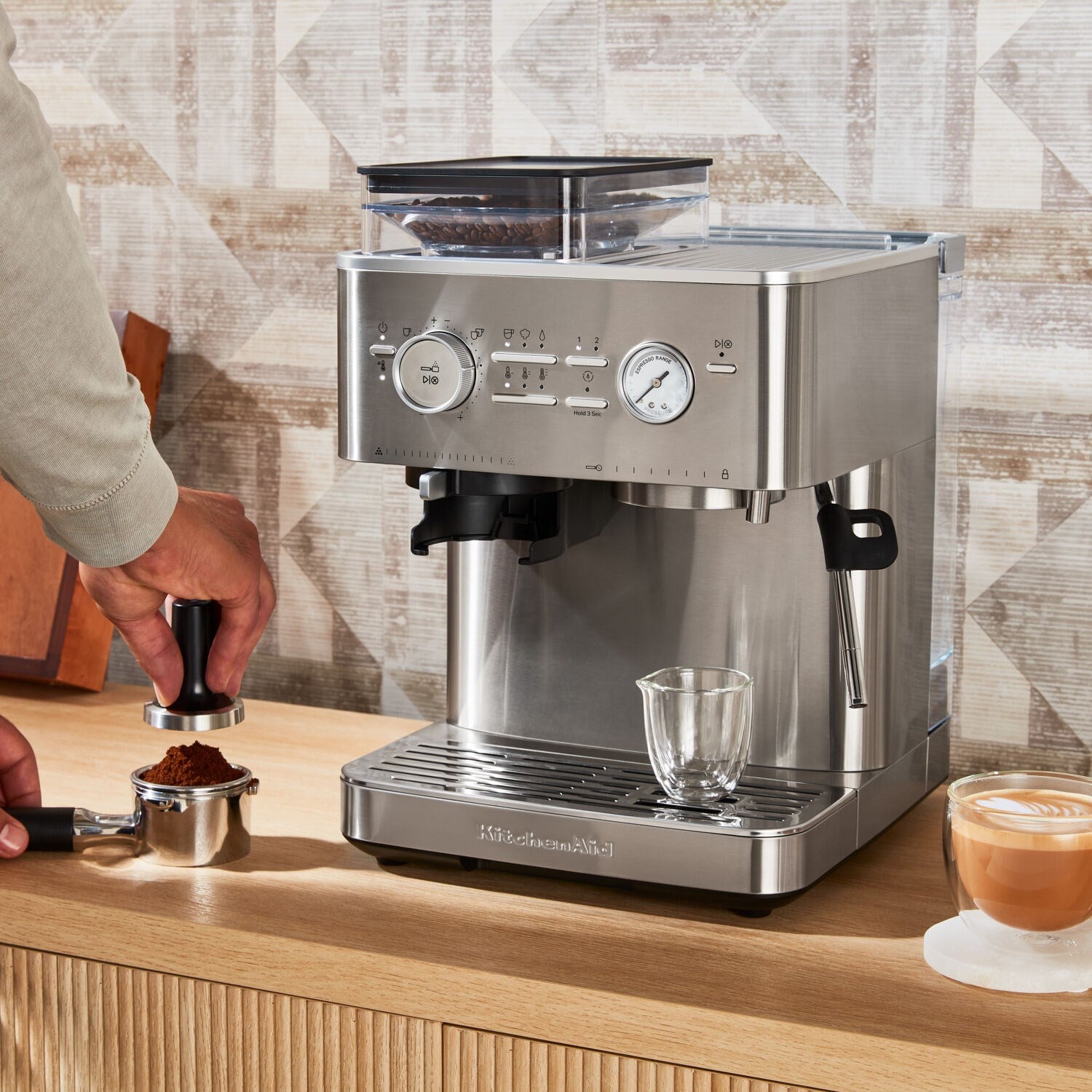 Stainless steel espresso machine with hand tamping grounds in the portafilter