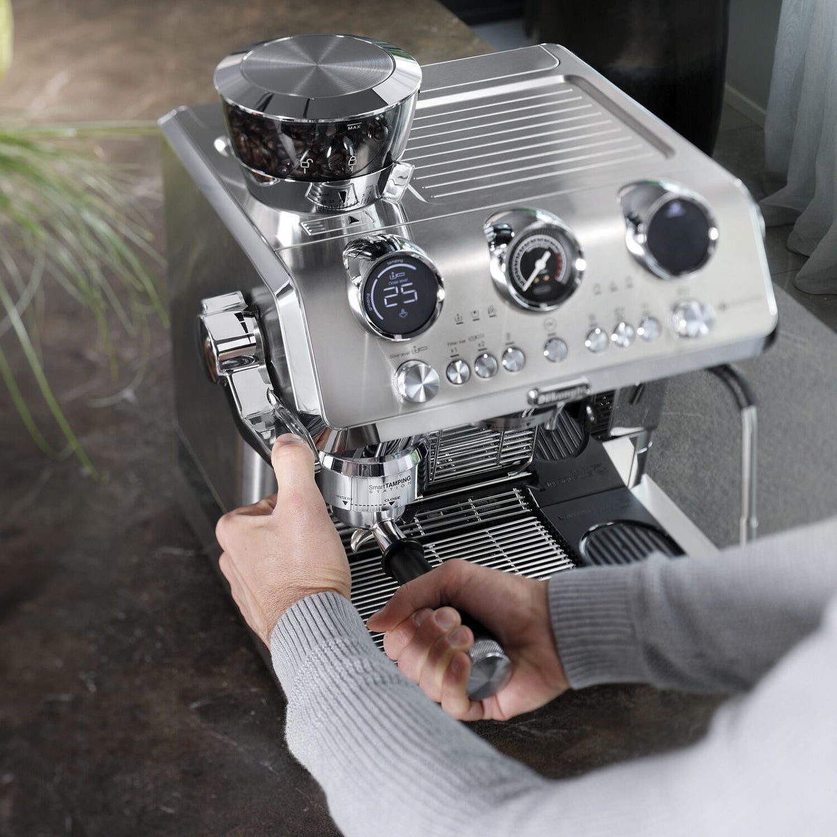 Stainless steel De'Longhi espresso machine with front controls and portafilter holder