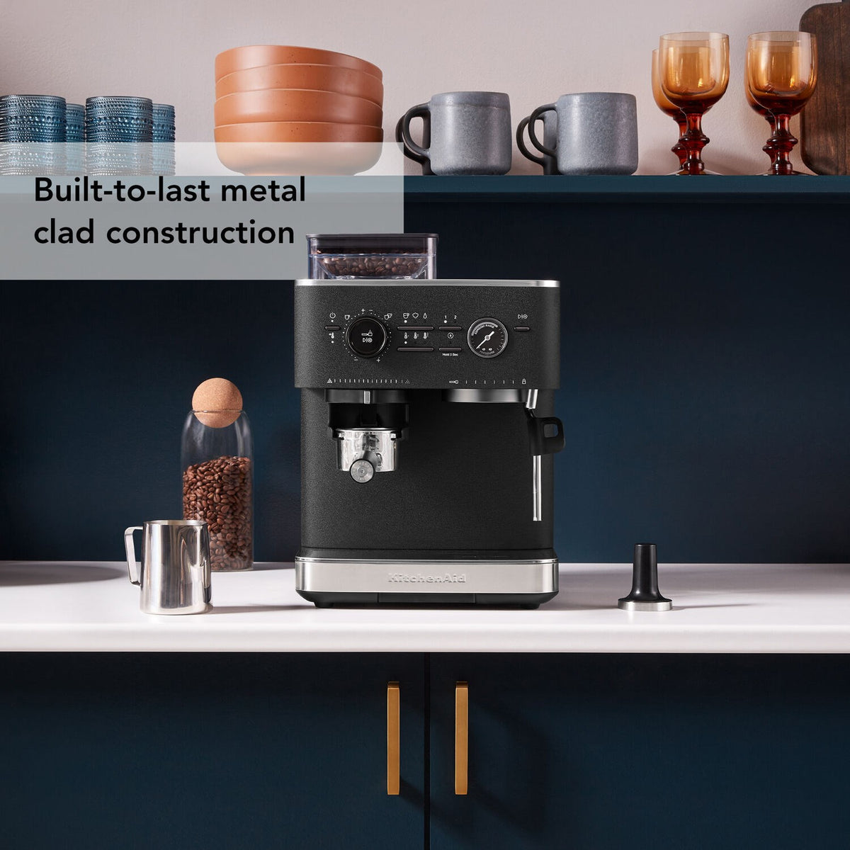 Black espresso machine with grinder hopper and control knobs, front brewing spout and base tray