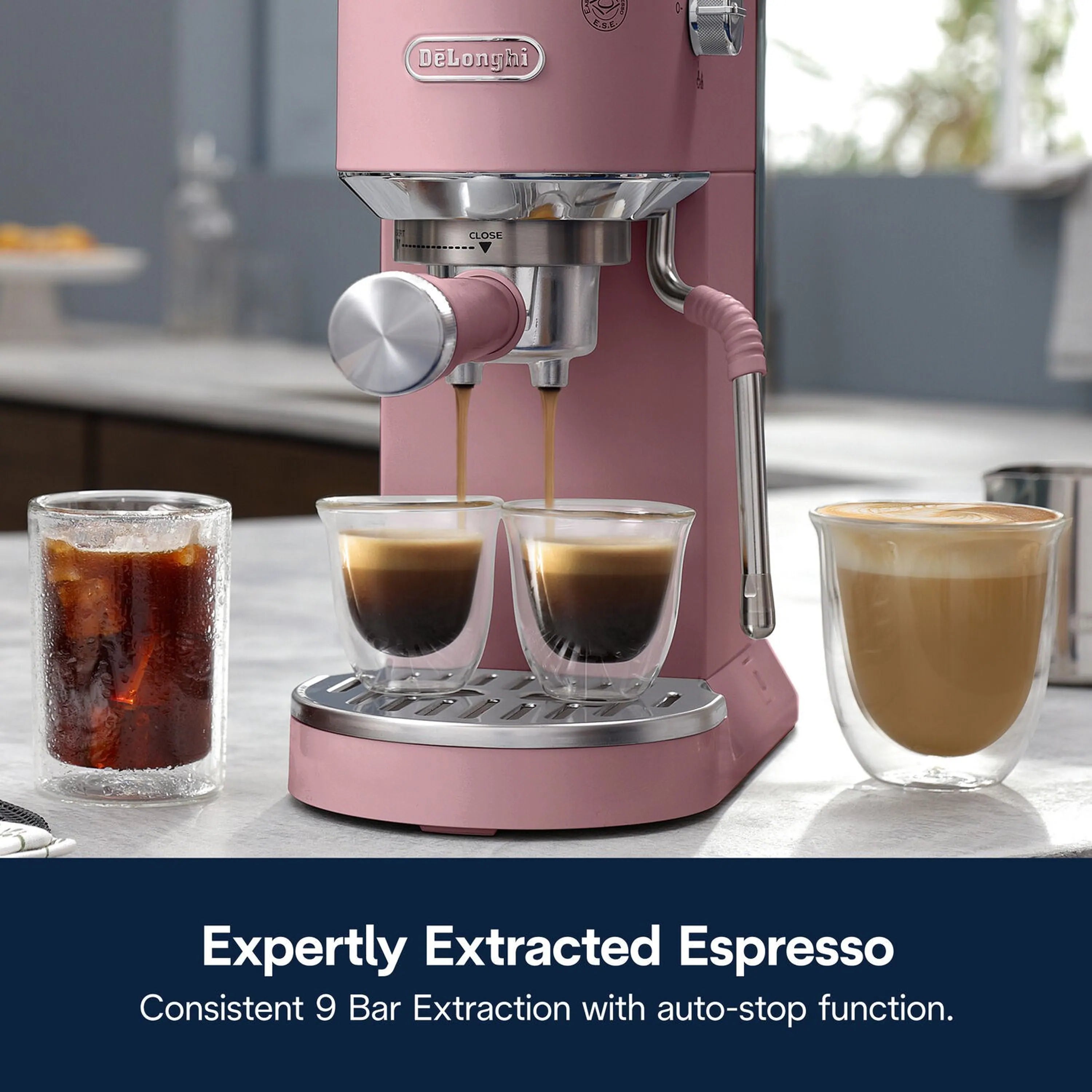 Pink espresso machine on countertop with three filled cups and steam wand