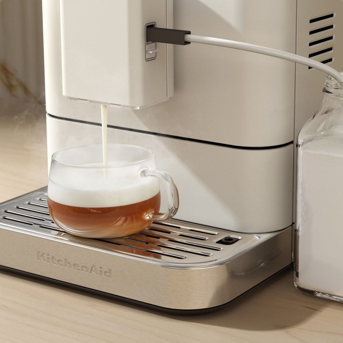 Porcelain white espresso machine with frothing spout and glass cup of crema