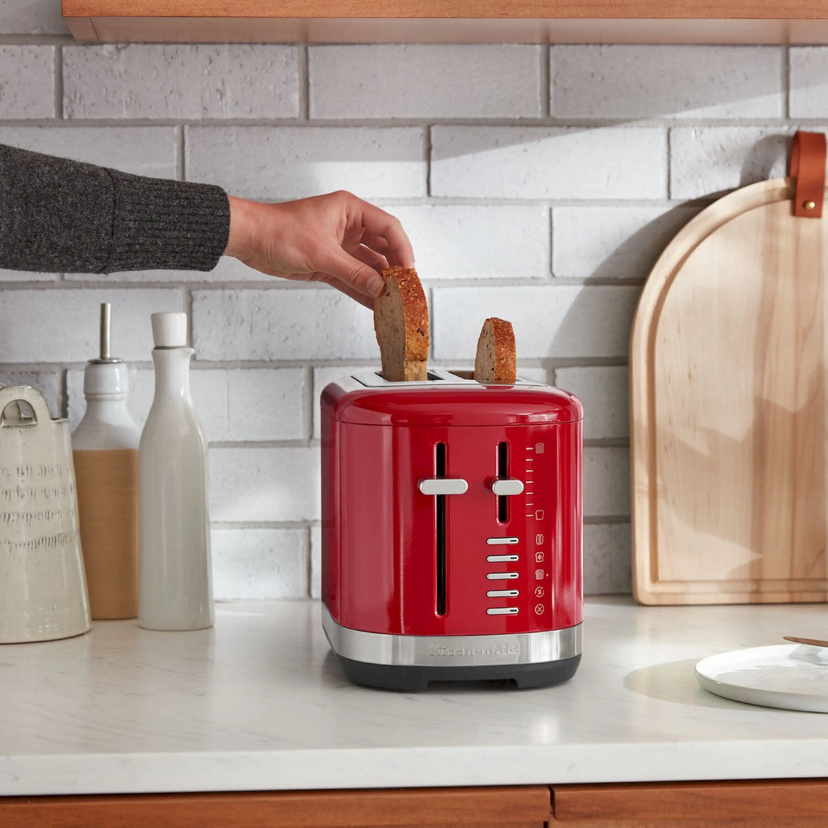 Empire Red 2-slice toaster on counter with bread in slots and lever