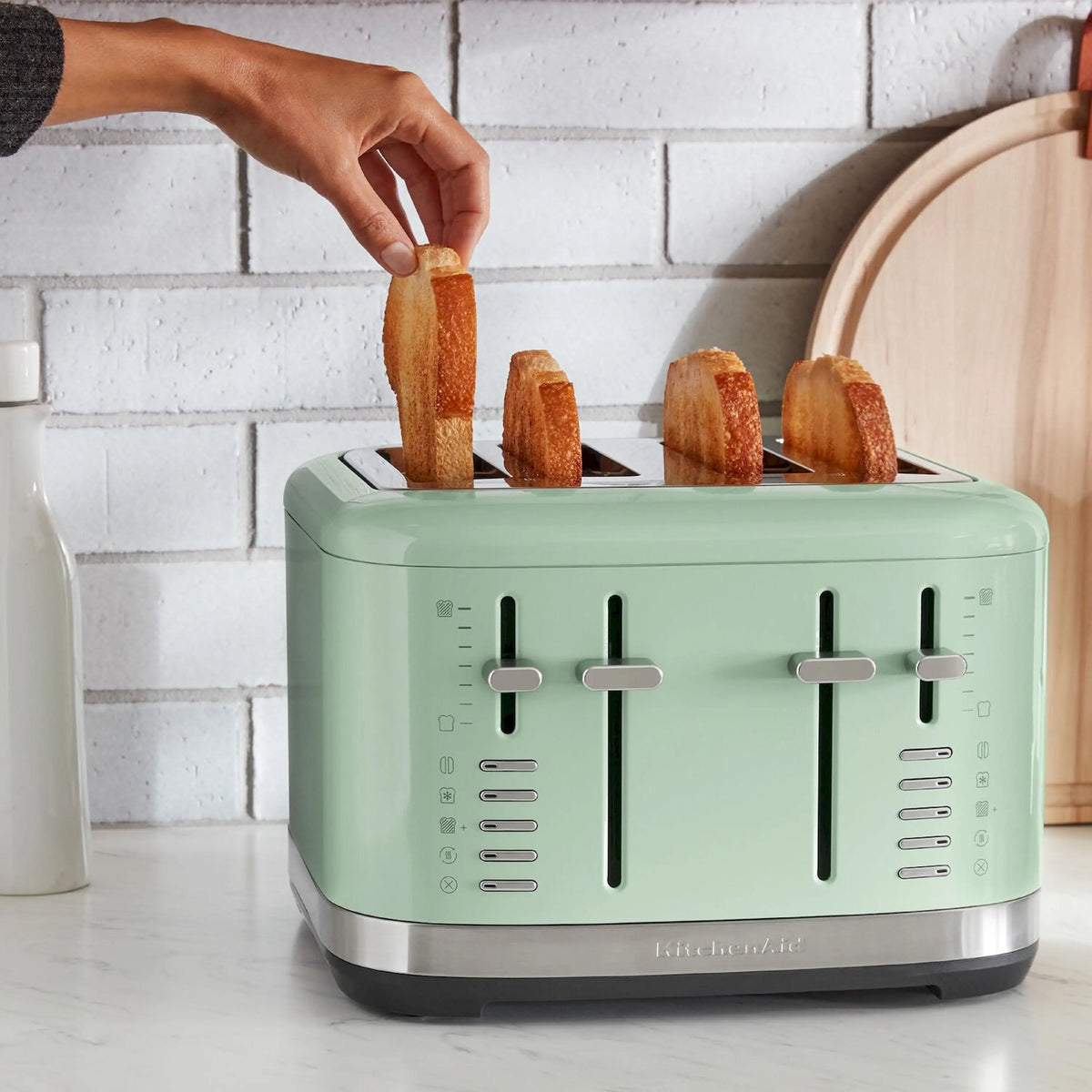 Pistacchio green 4-slice toaster with wide slots and levers, with bread inserted