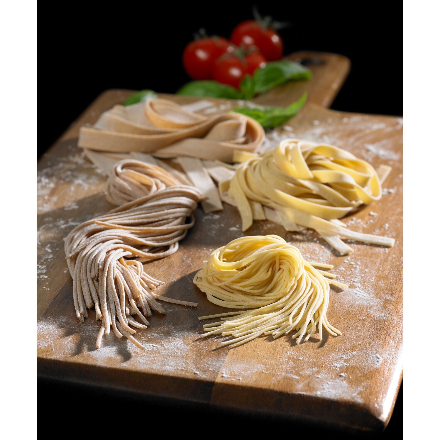 Fresh pasta nests and noodle strands on board