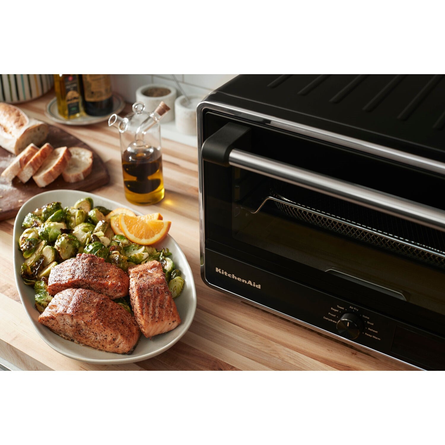 KitchenAid black countertop oven with glass door and digital controls, shown in side view