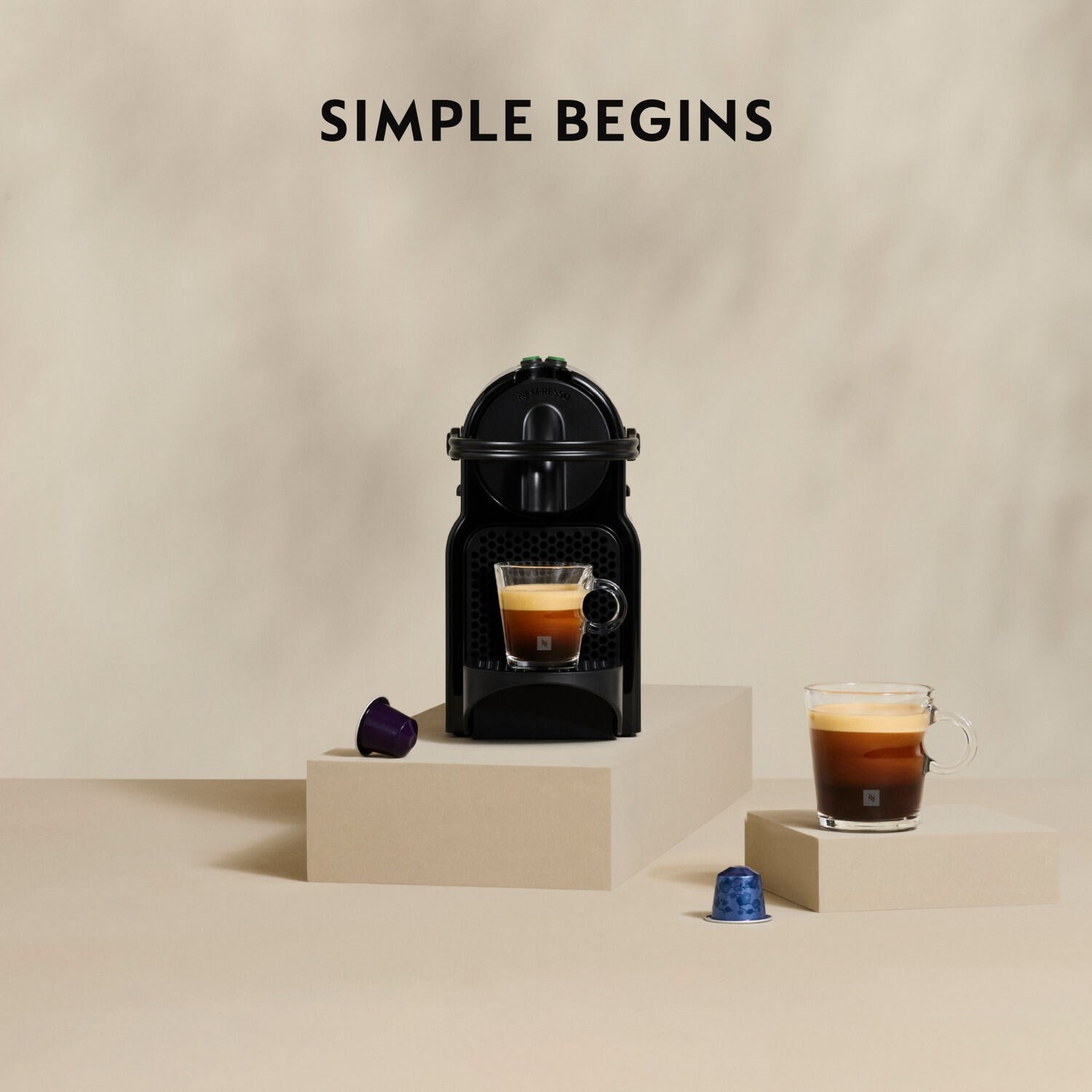 Black Nespresso espresso machine with cup and small coffee capsule