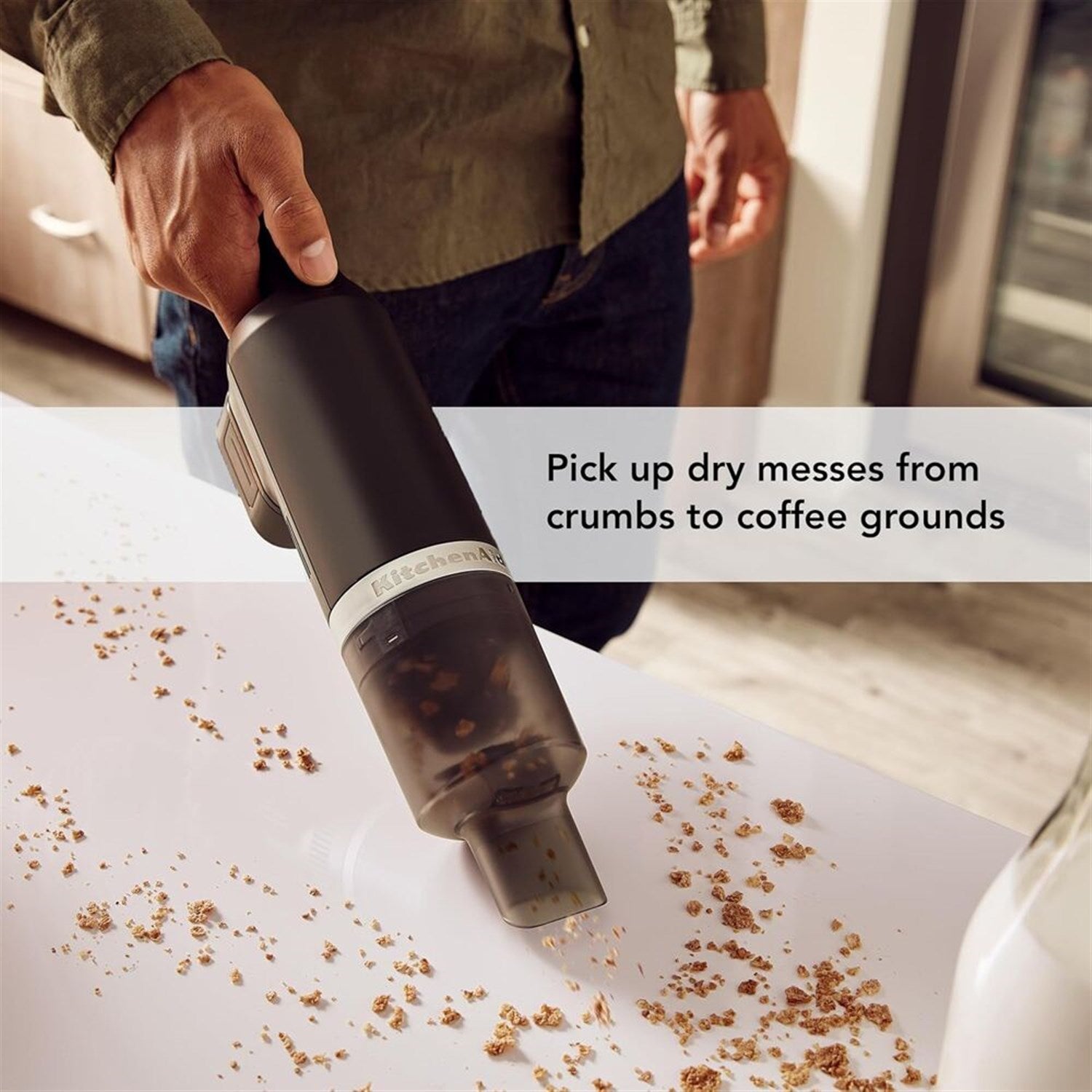 KitchenAid cordless kitchen vacuum nozzle in use on countertop with crumbs