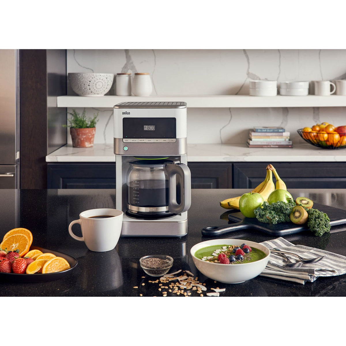 Stainless steel and white 12-cup drip coffee maker with carafe and control panel centered