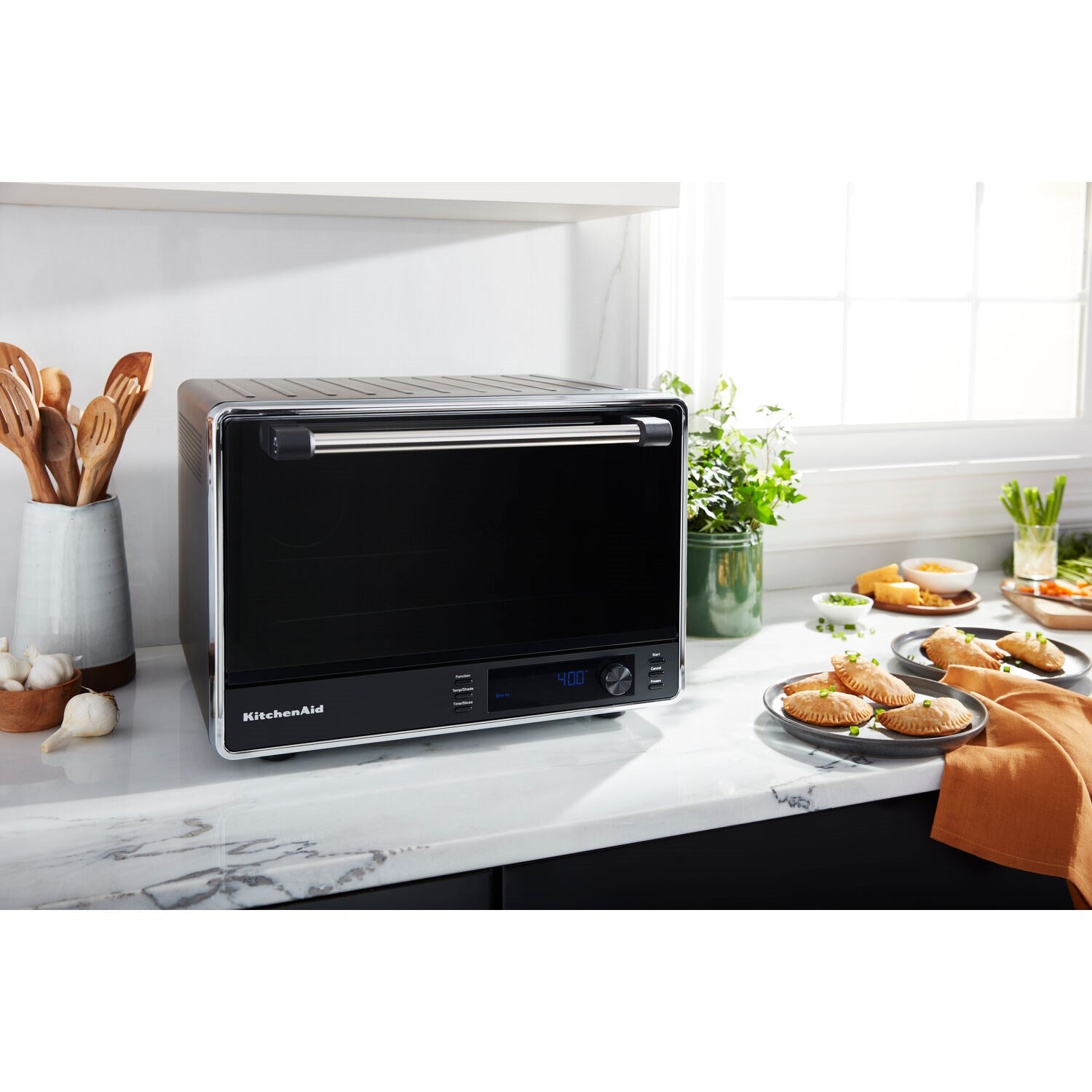 Black matte countertop convection oven with digital display and closed door on a countertop