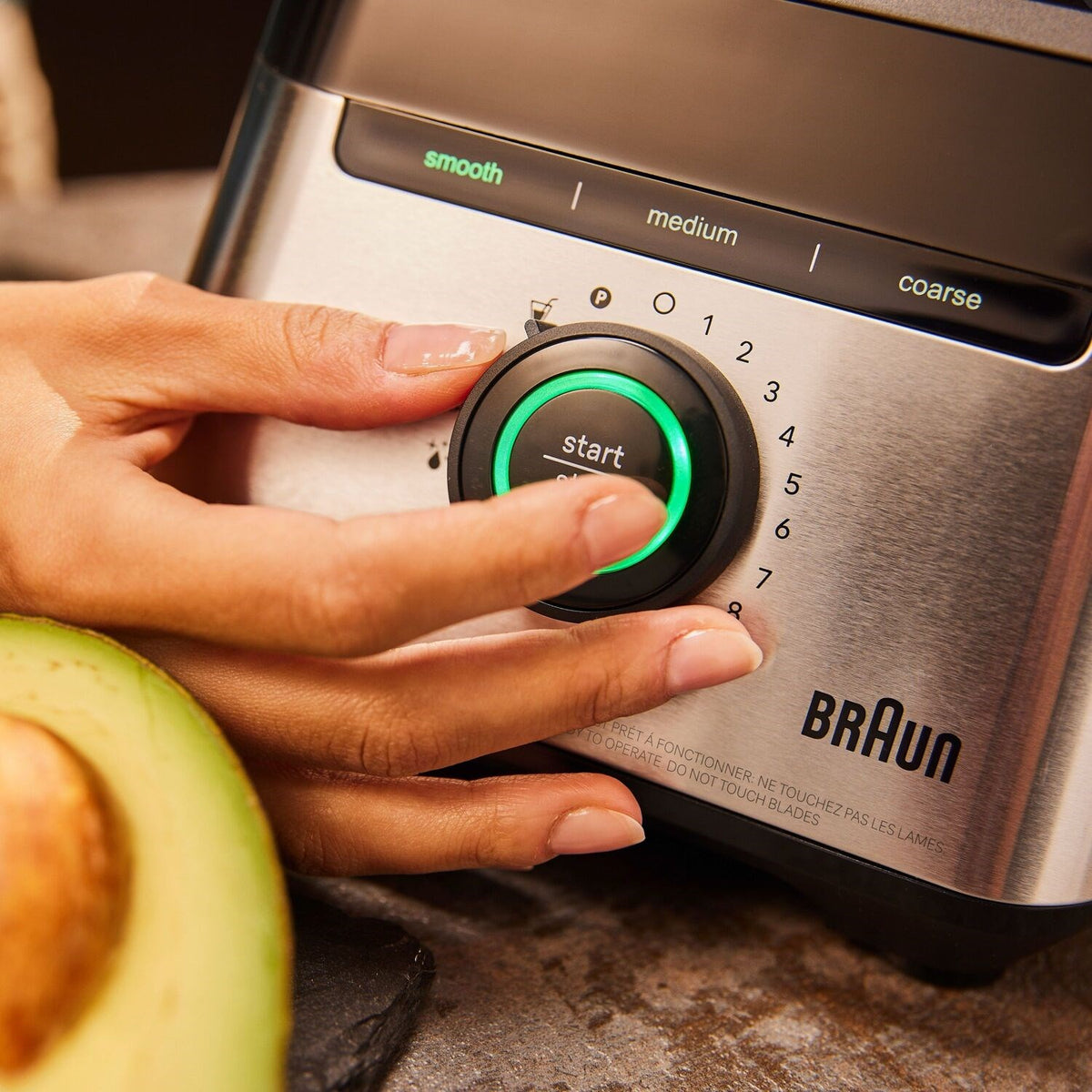 Braun blender base with start dial and smooth/medium/coarse speed options, in use.