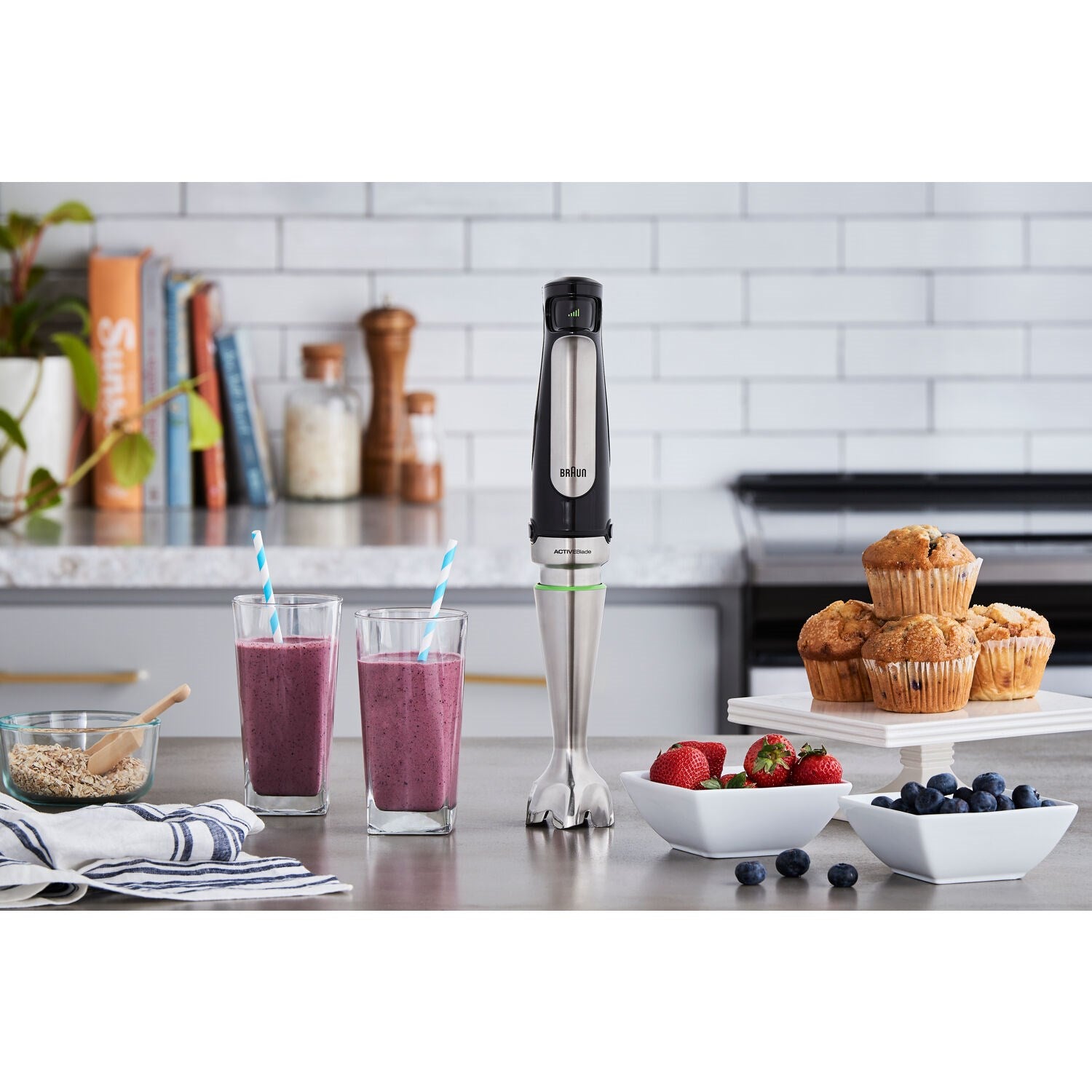 Braun hand blender standing on counter with mixing attachment and cup