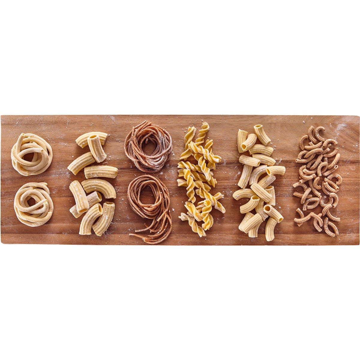 Assorted pasta shapes made with a white KitchenAid pasta press: shells, spirals, and ribbons.